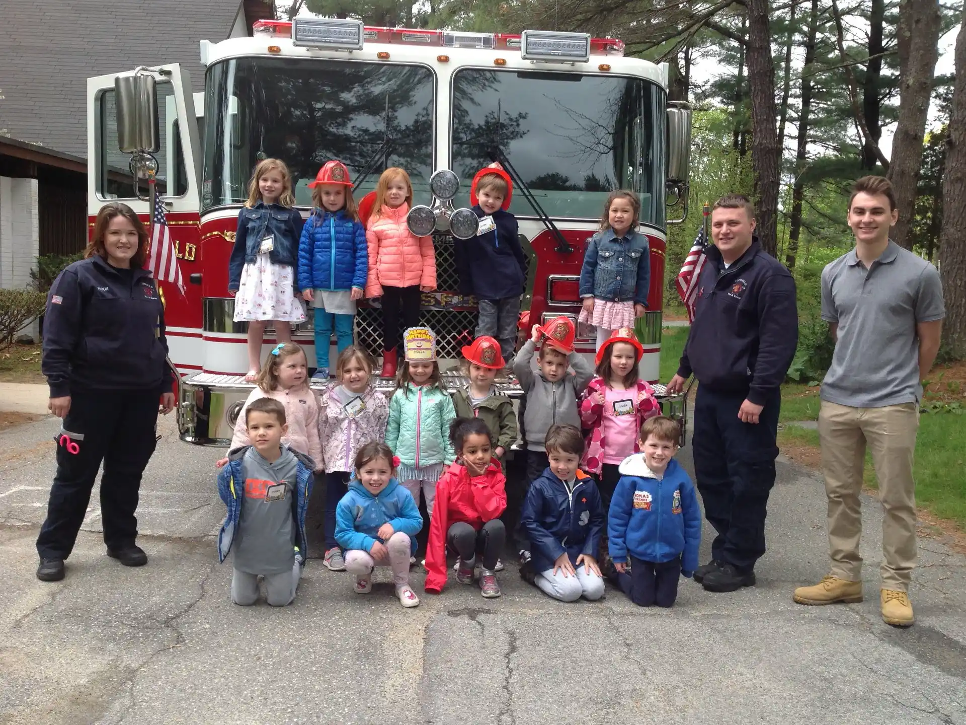 a group of people posing for a photo in front of a fire truck