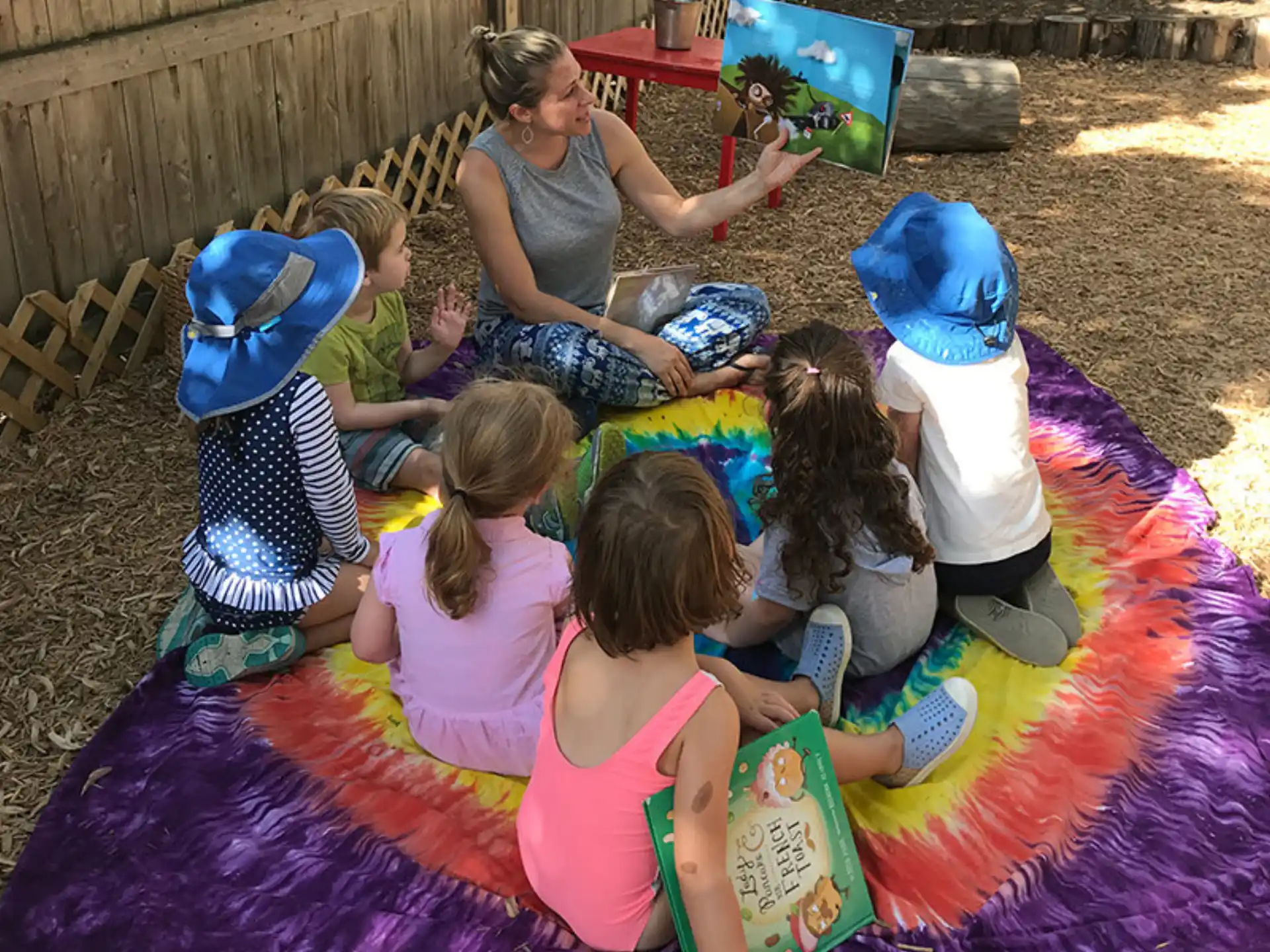a group of children sitting on a blanket on a blanket