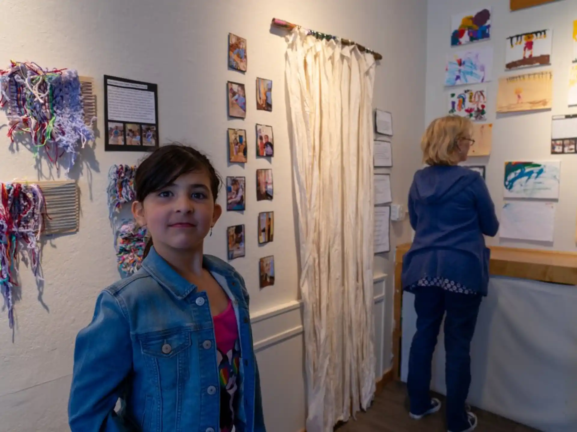 a person standing in a room with pictures on the wall