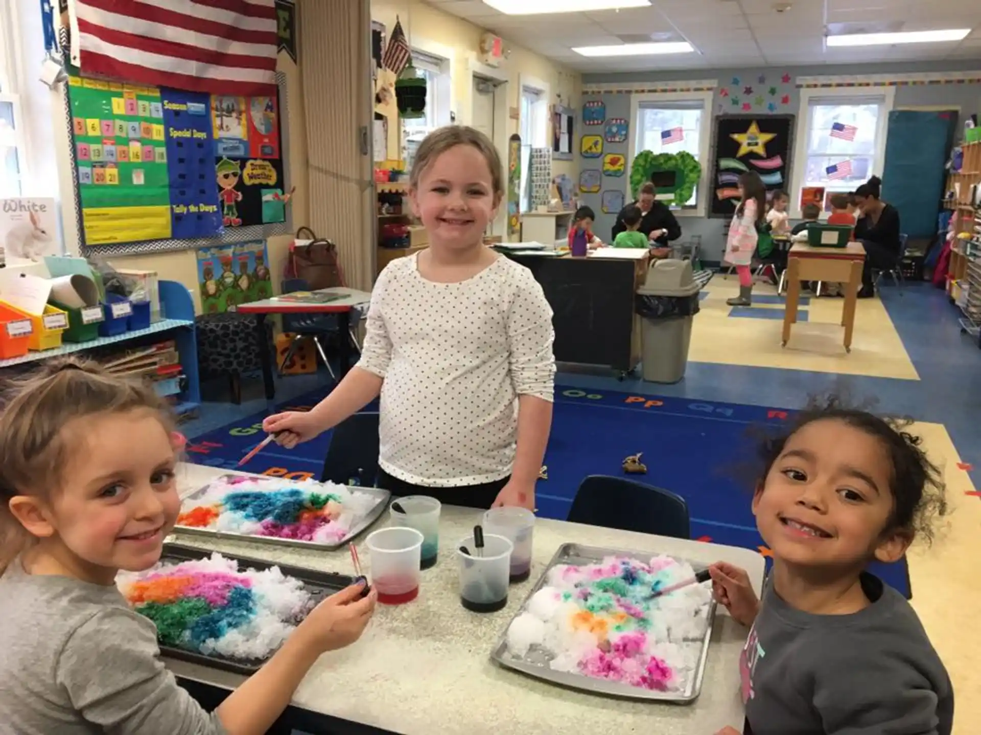 a group of children sitting at a table with a cake
