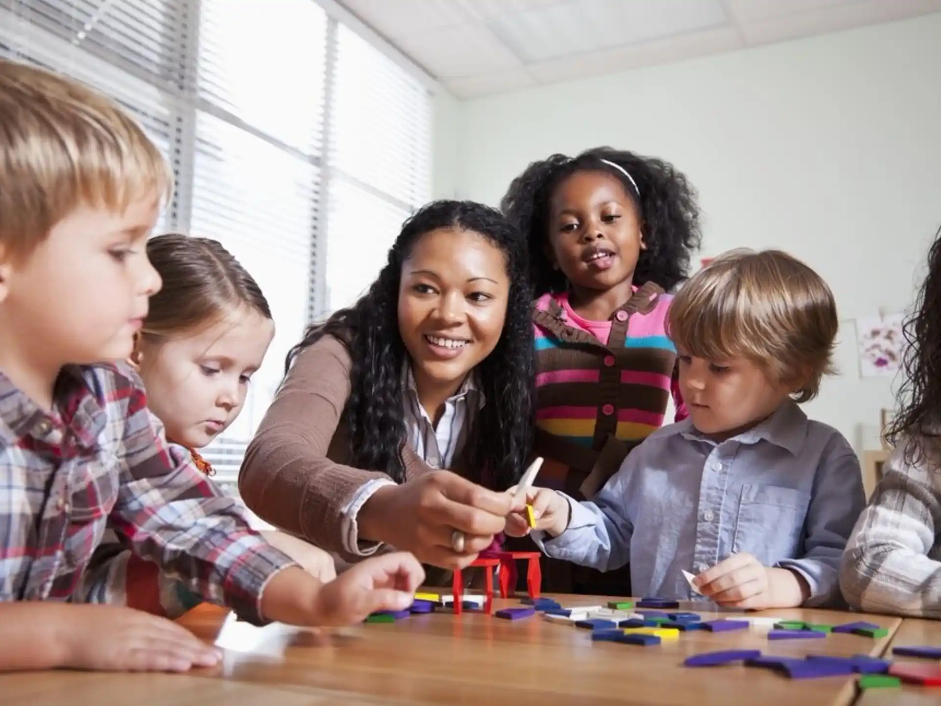 a person and several children sitting at a table