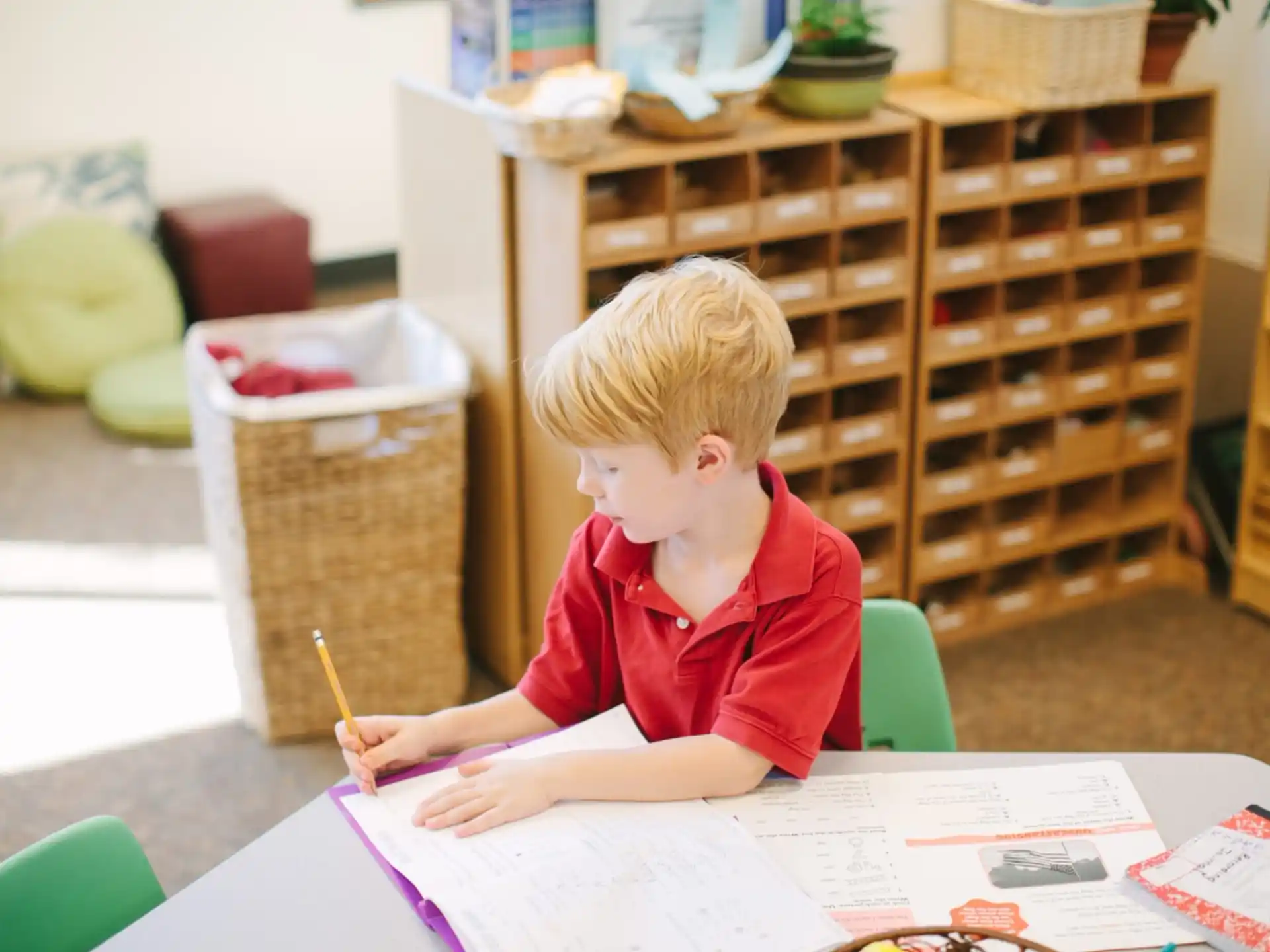 a child sitting at a table writing