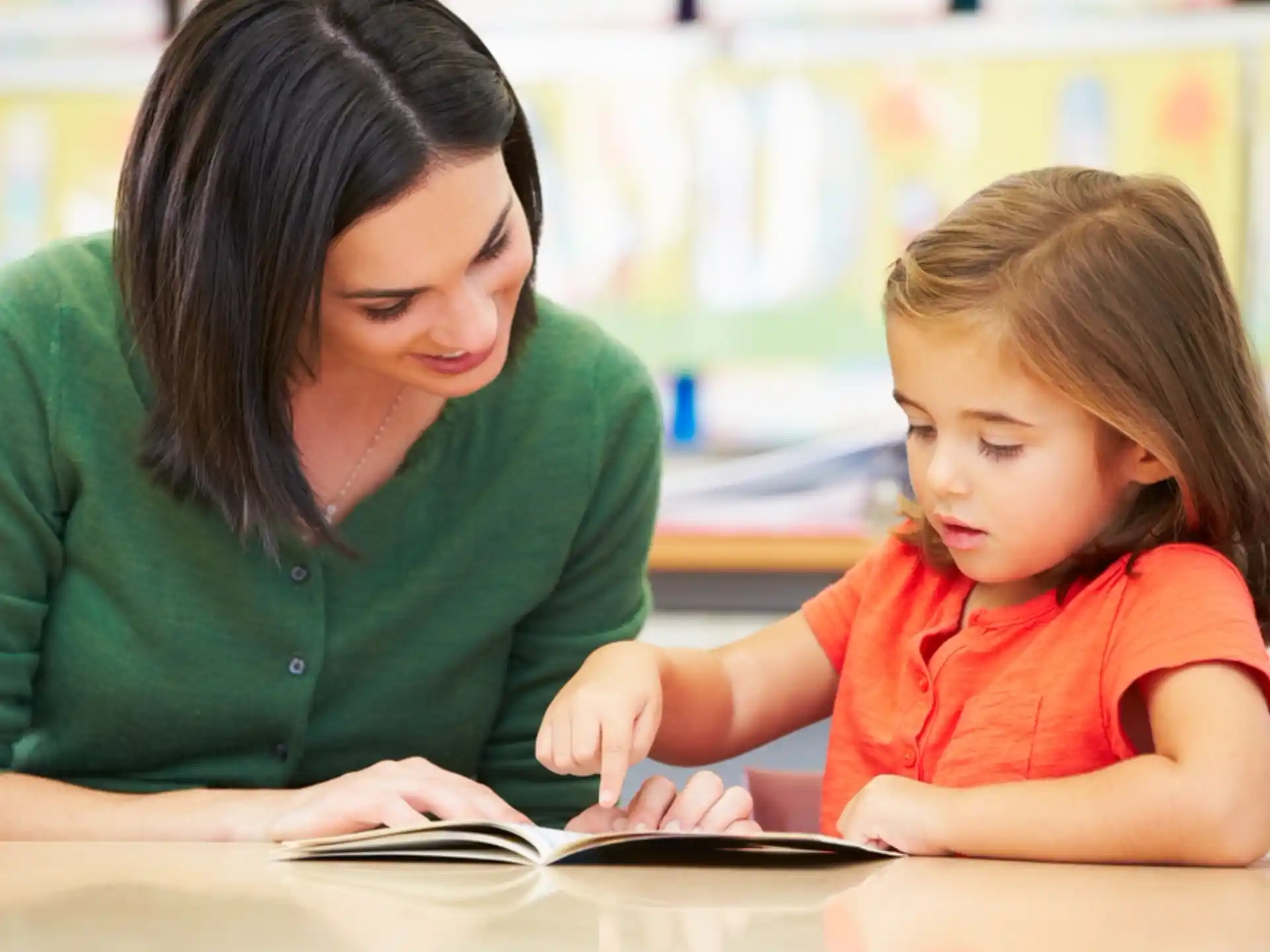 a woman and a child looking at a book