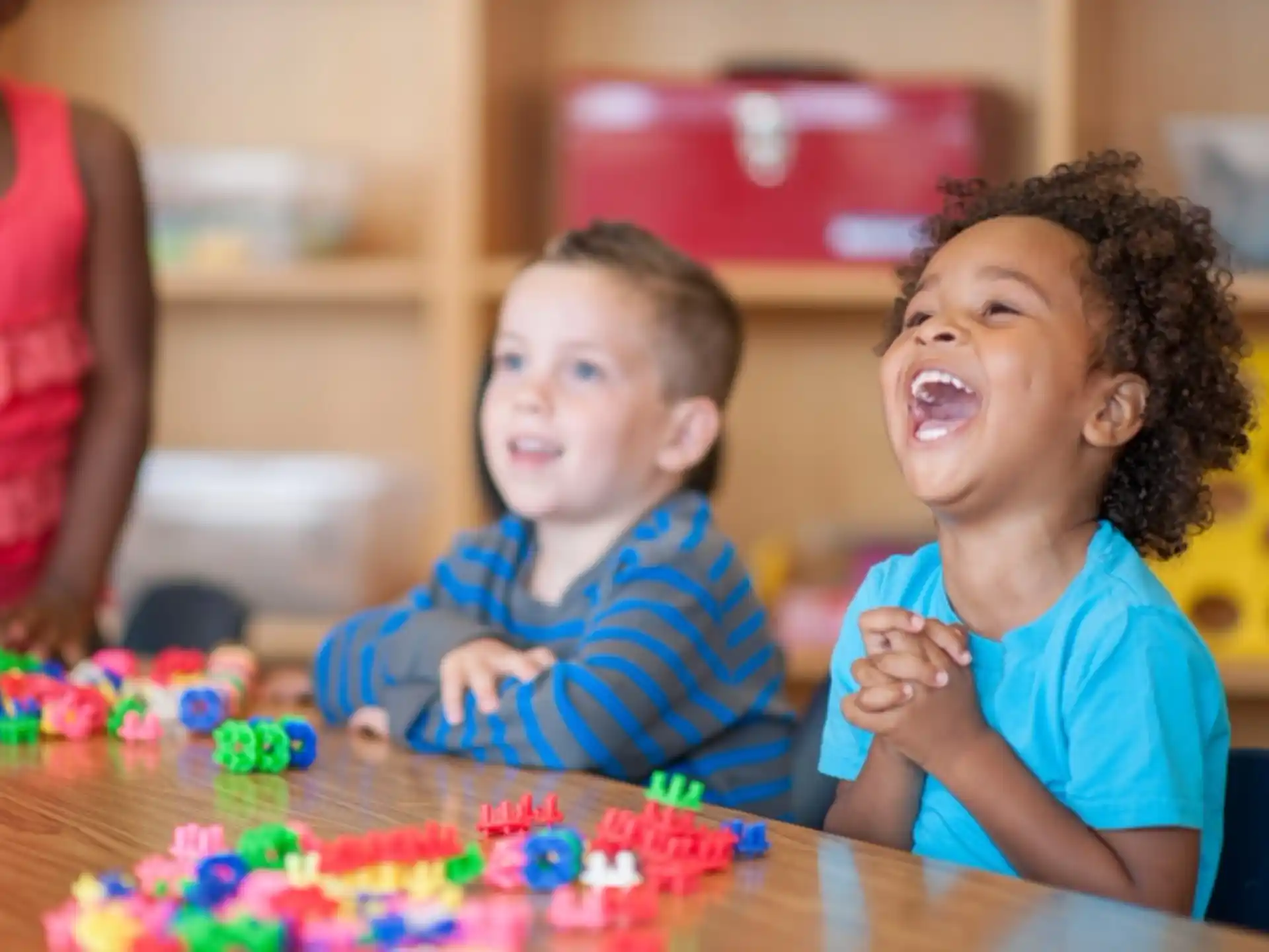 a couple of kids sitting at a table with a cake