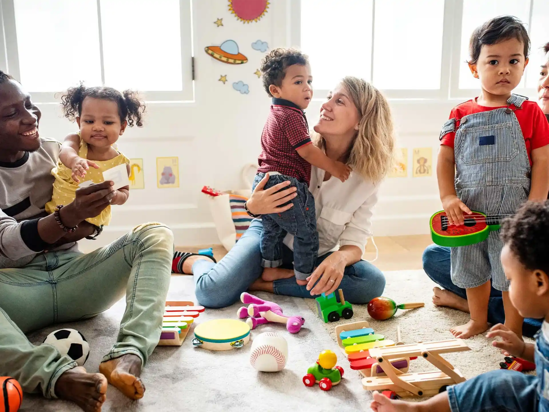 a group of people sitting on the floor playing with toys