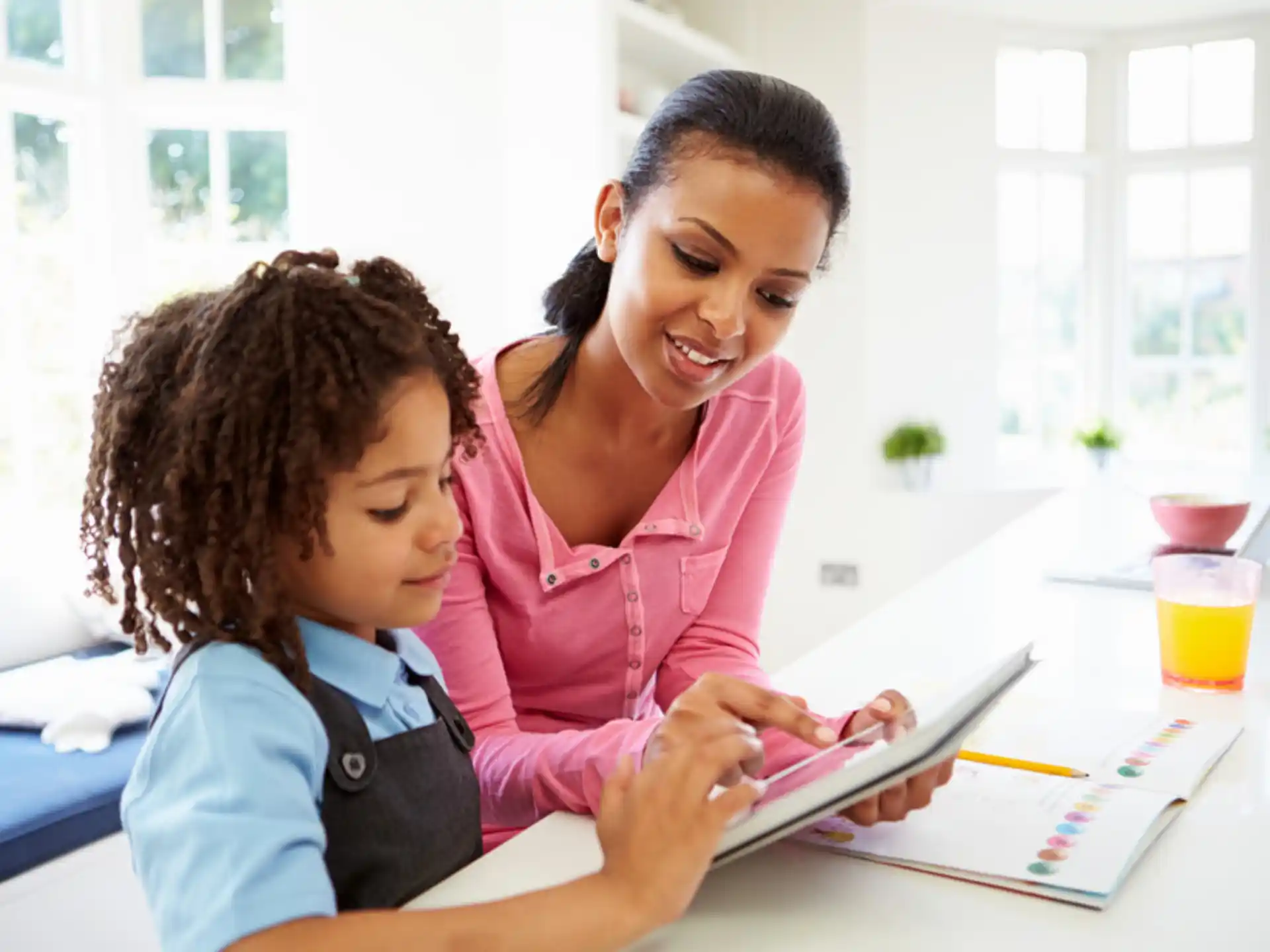 a woman and a child looking at a tablet