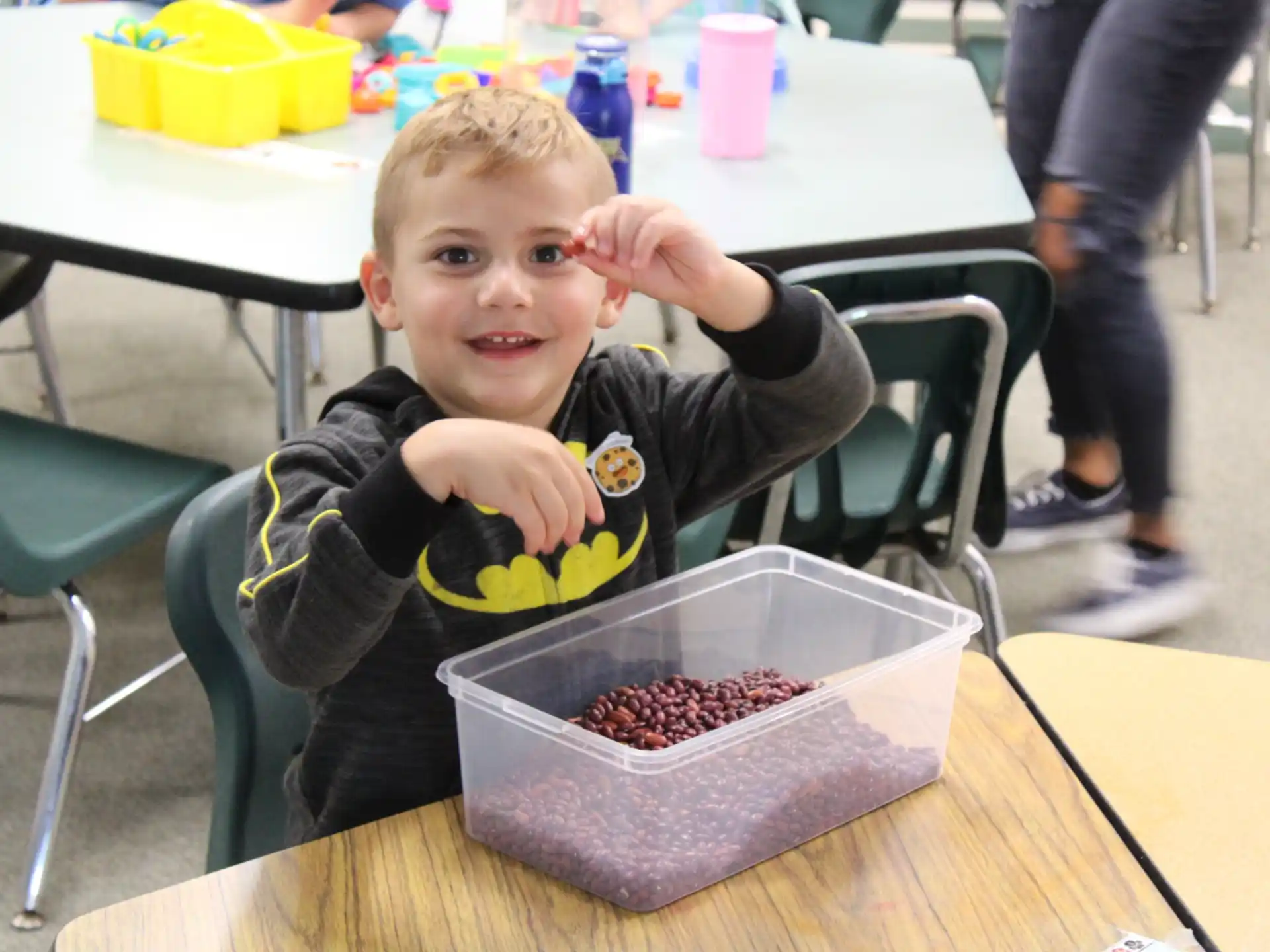 a boy sitting at a table with a tray of food