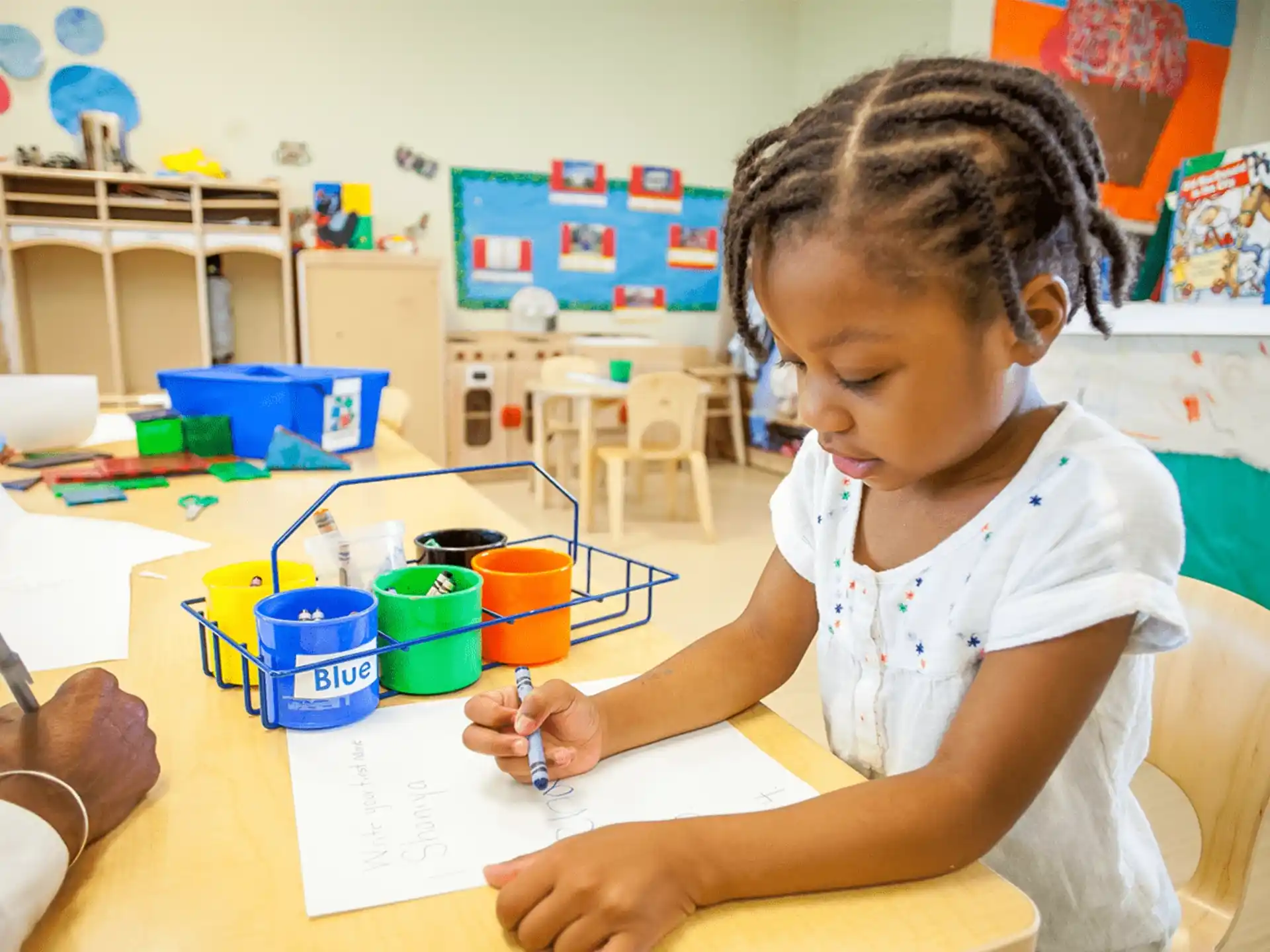 a young girl writing on a paper