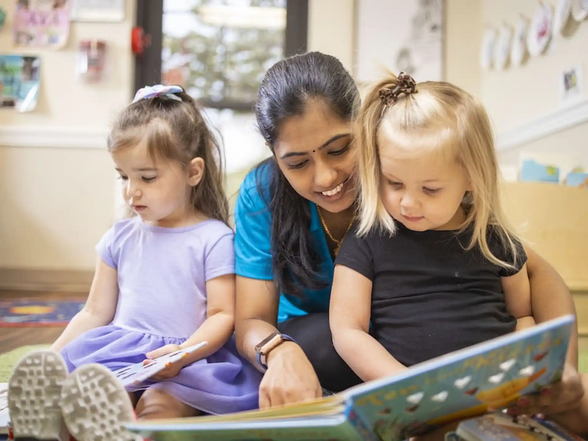 a person and two children looking at a tablet
