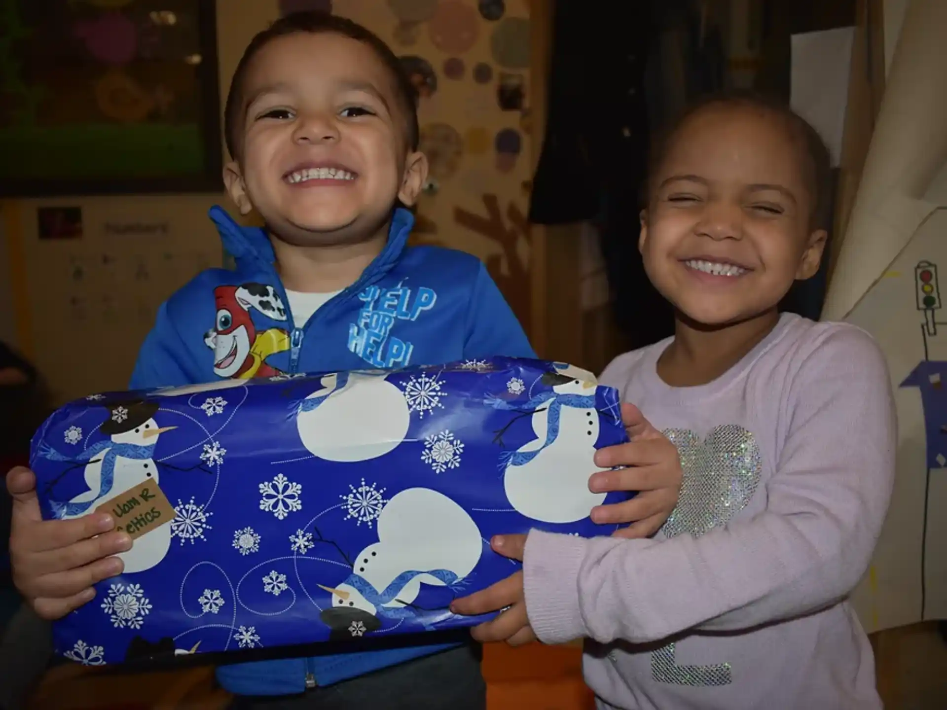 a couple of children holding a box