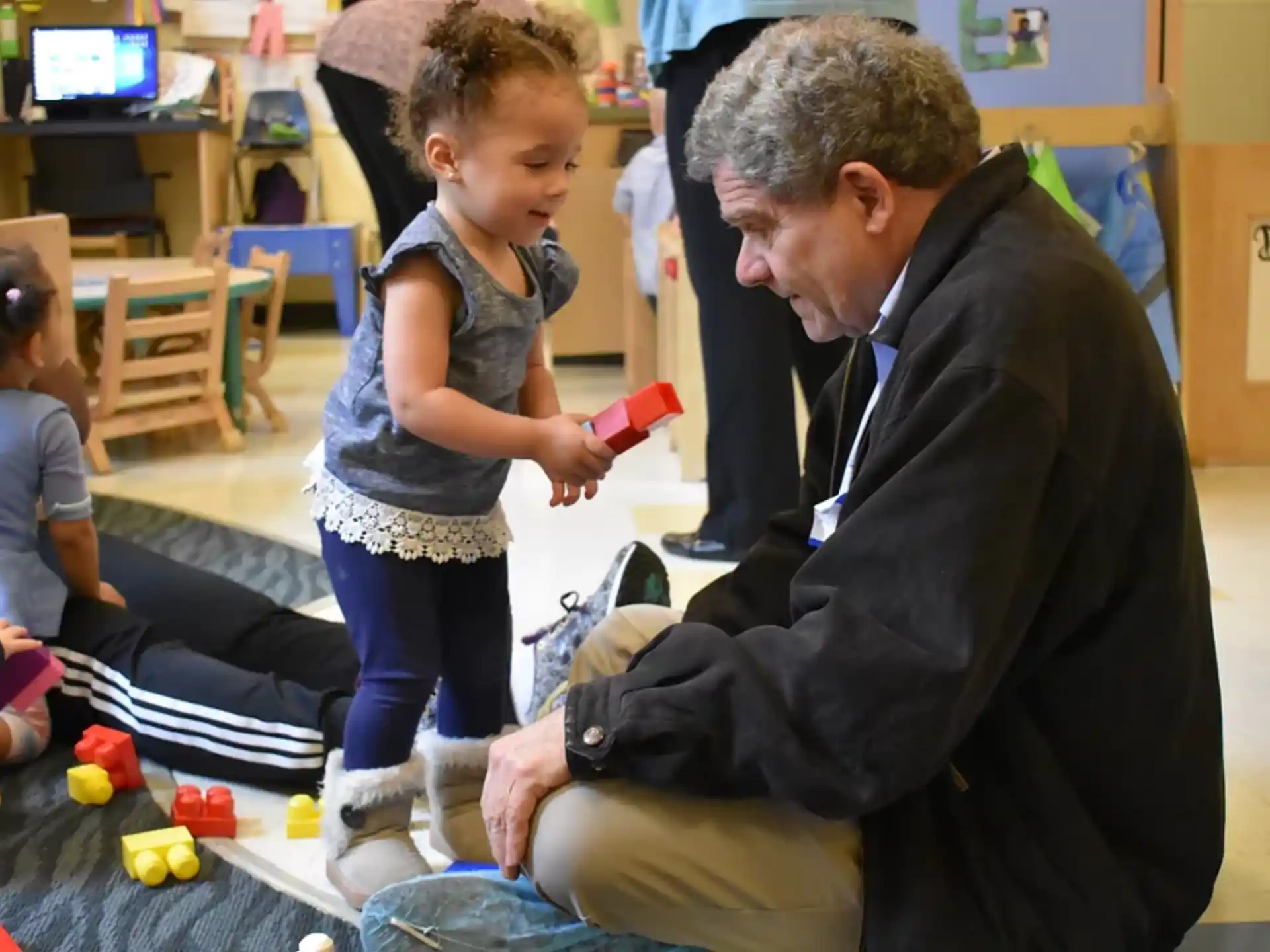 a person and a child playing with toys in a room