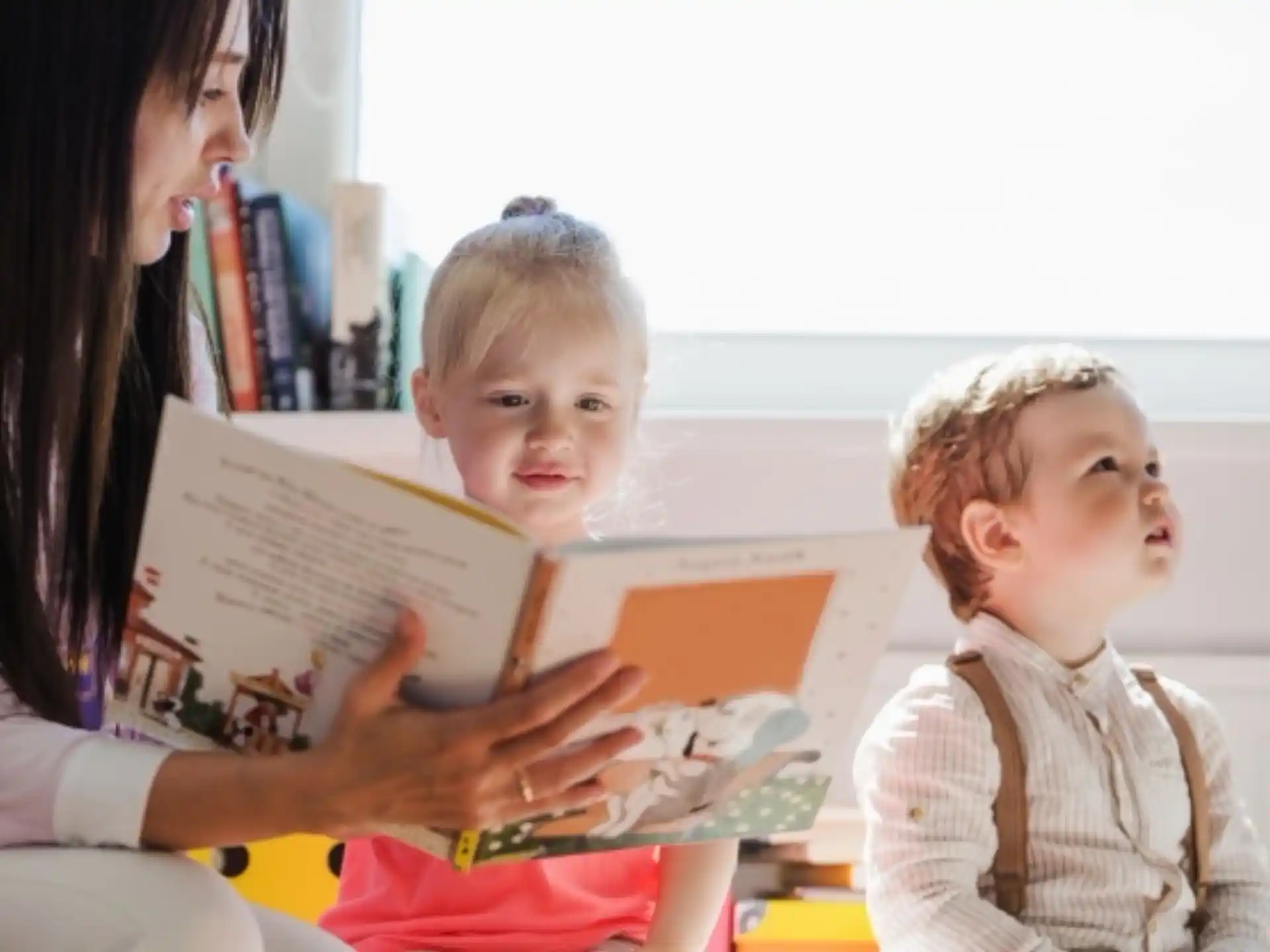 a person reading a book to a child