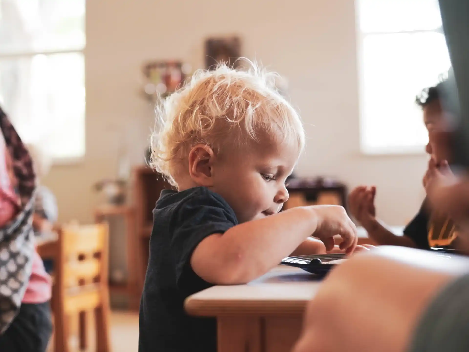 a young boy playing with a tablet