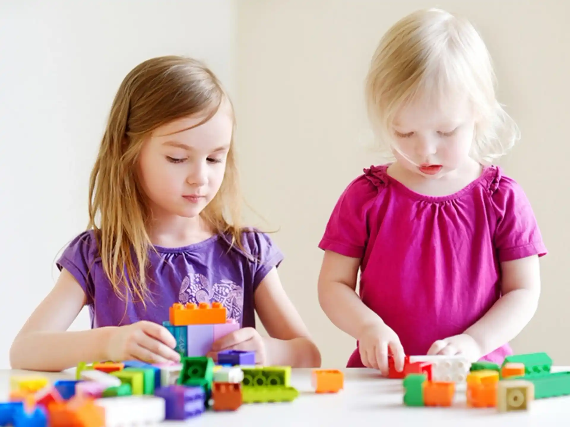 a couple of young girls playing with toys