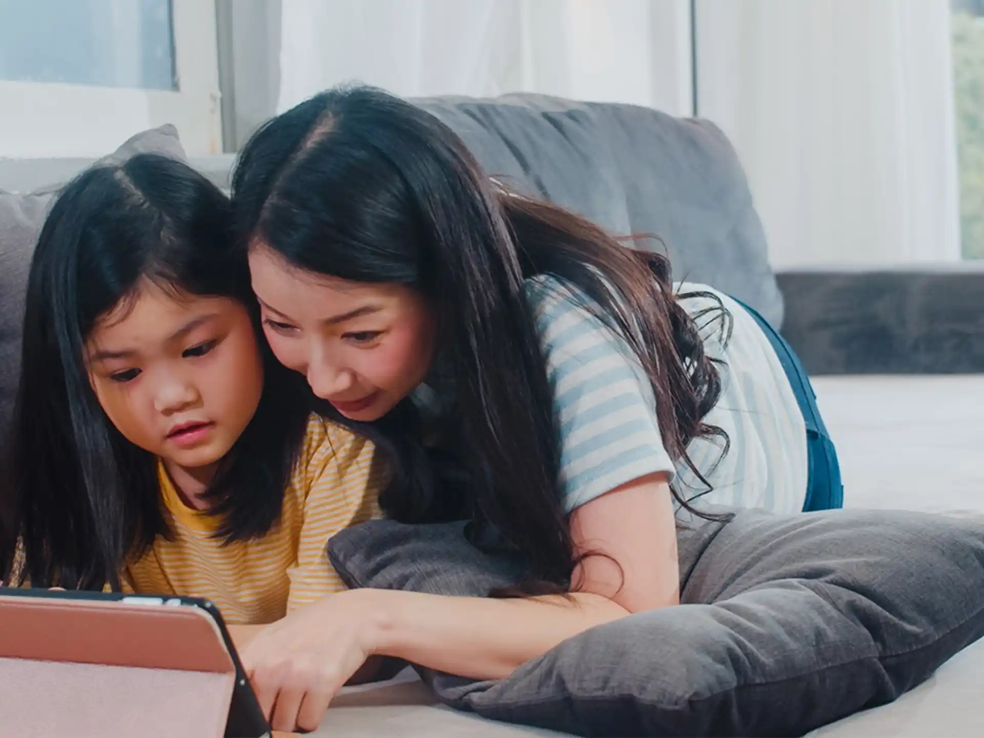 a couple of women looking at a laptop