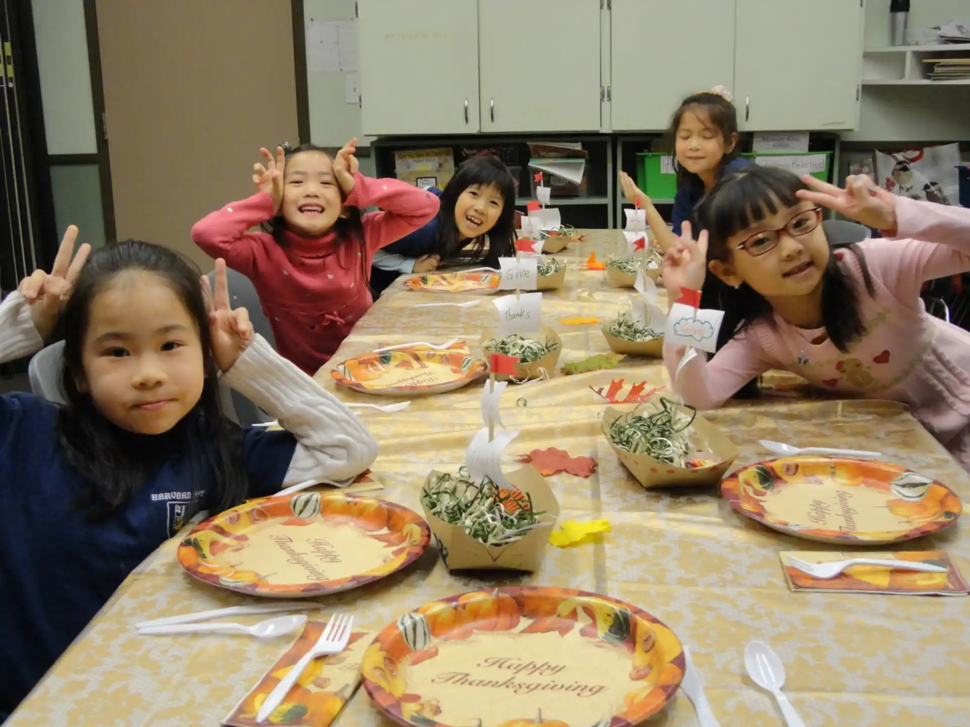 a group of girls sitting at a table with food on it