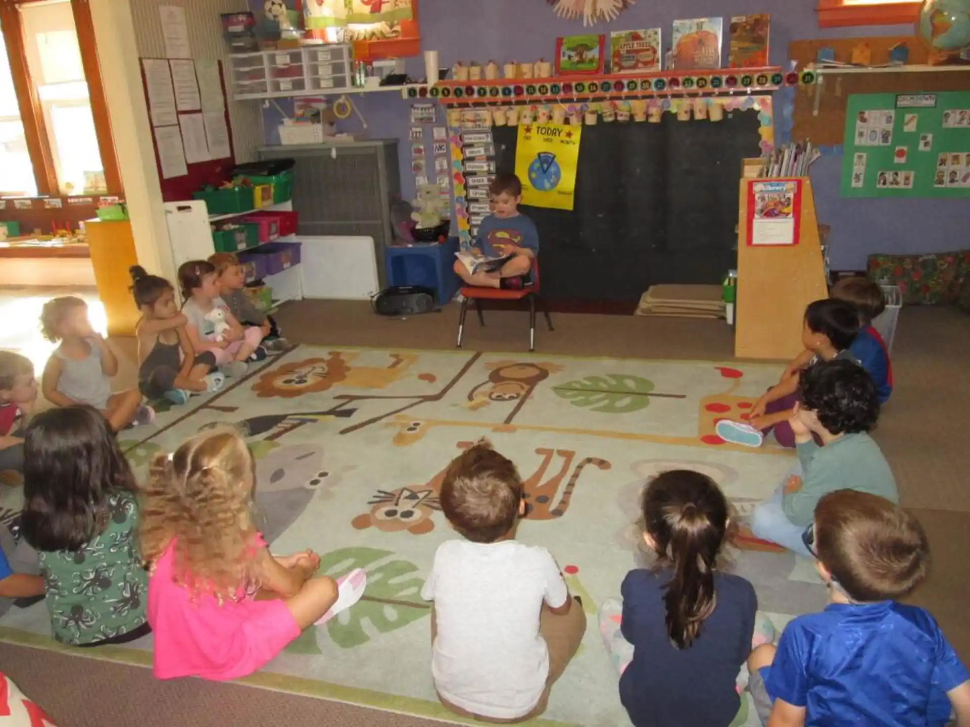 a group of children sitting on the floor in a classroom