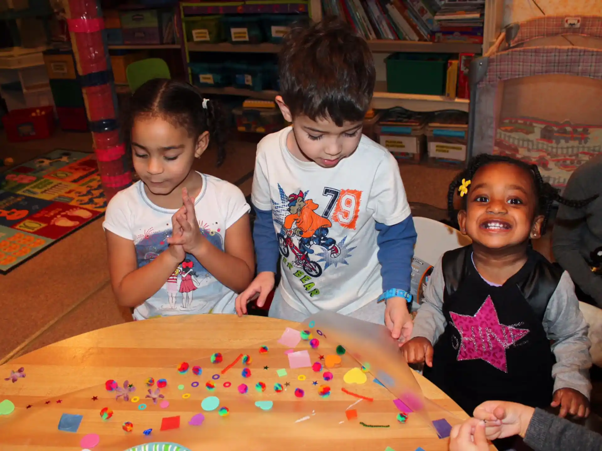 a group of children sitting at a table with a board game