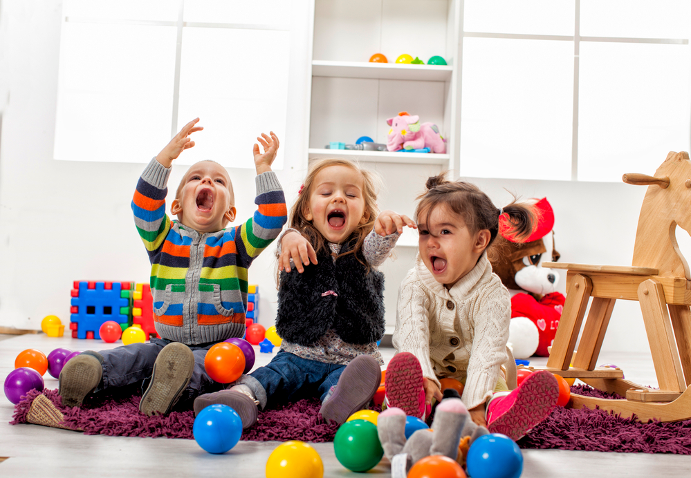 a group of children sitting on the floor with balloons