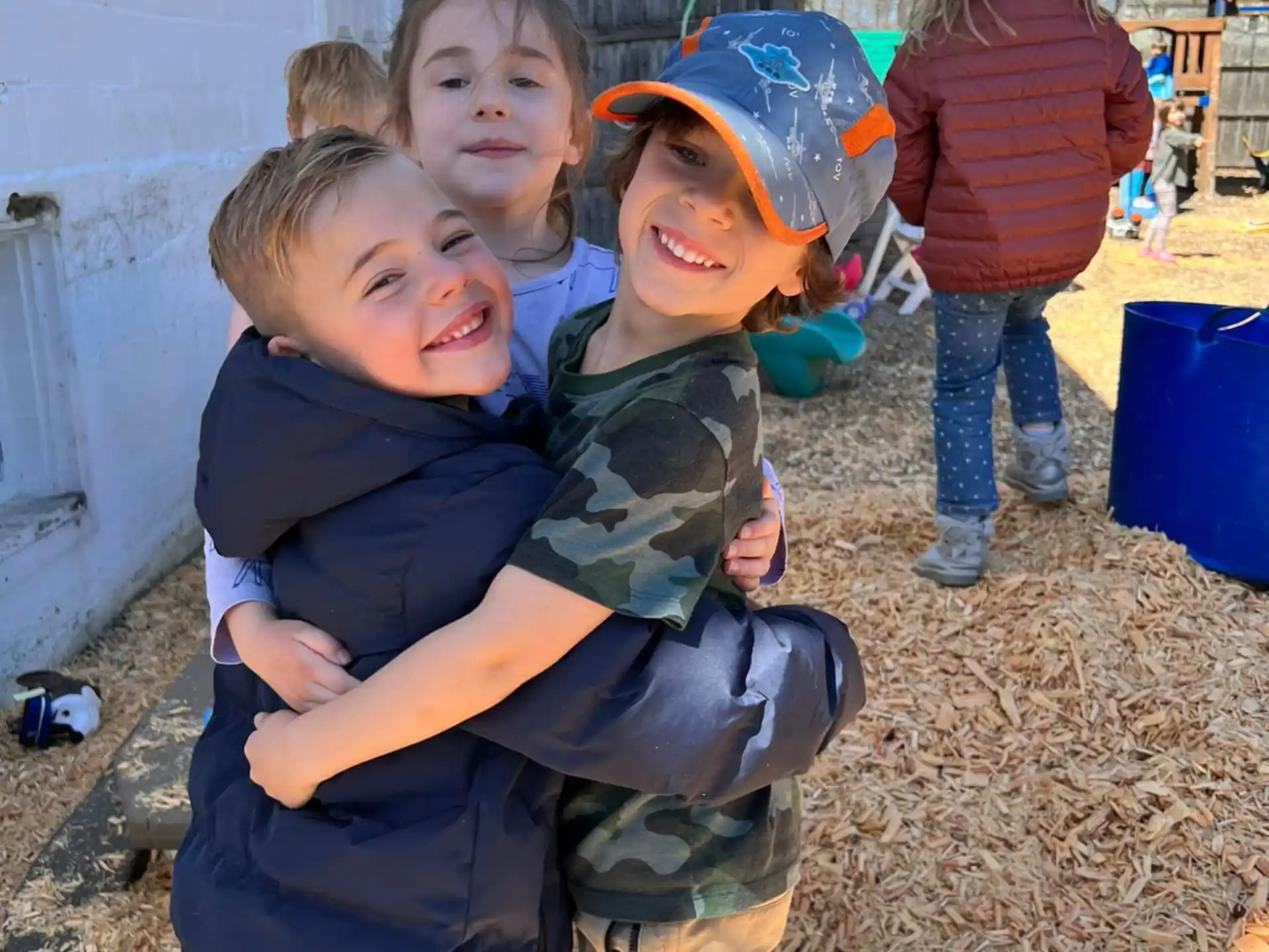 a group of children hugging outside