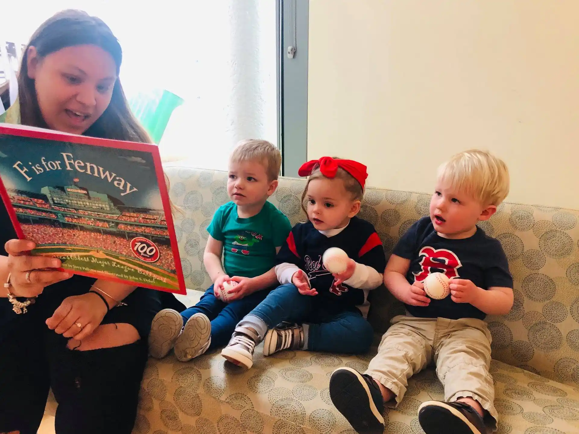a man and several children sitting on the floor holding books