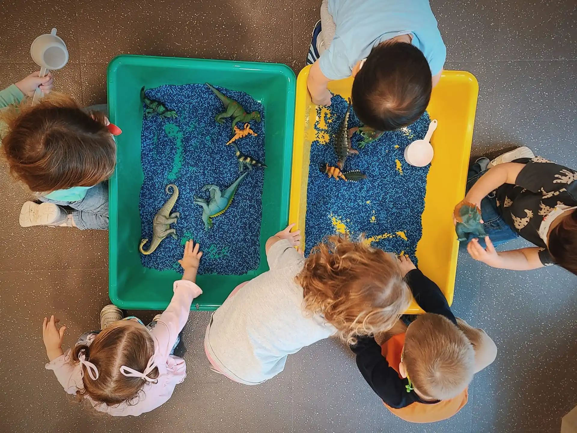 a group of children playing on a yellow and green slide