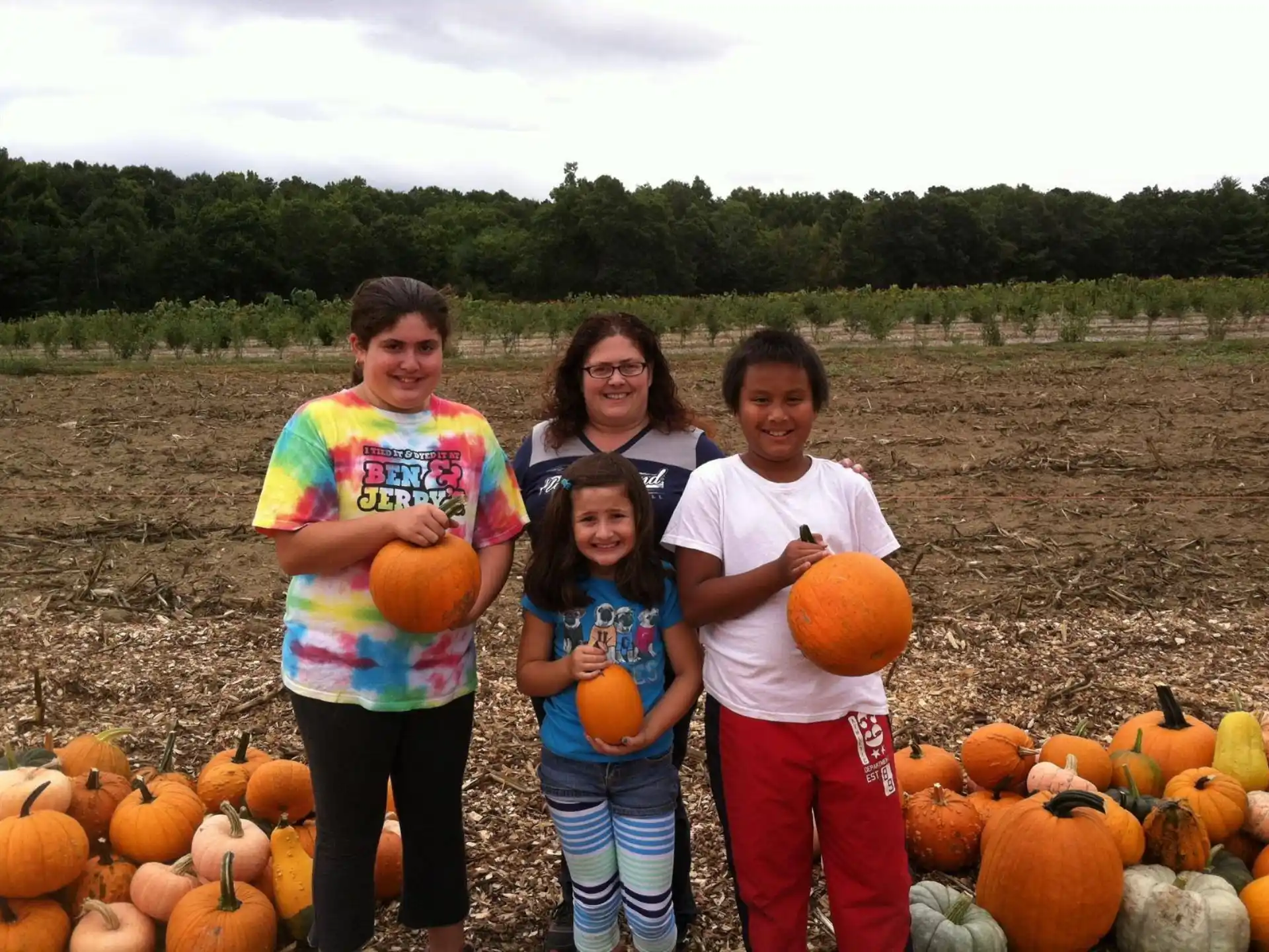 a group of people posing for a photo in front of pumpkins