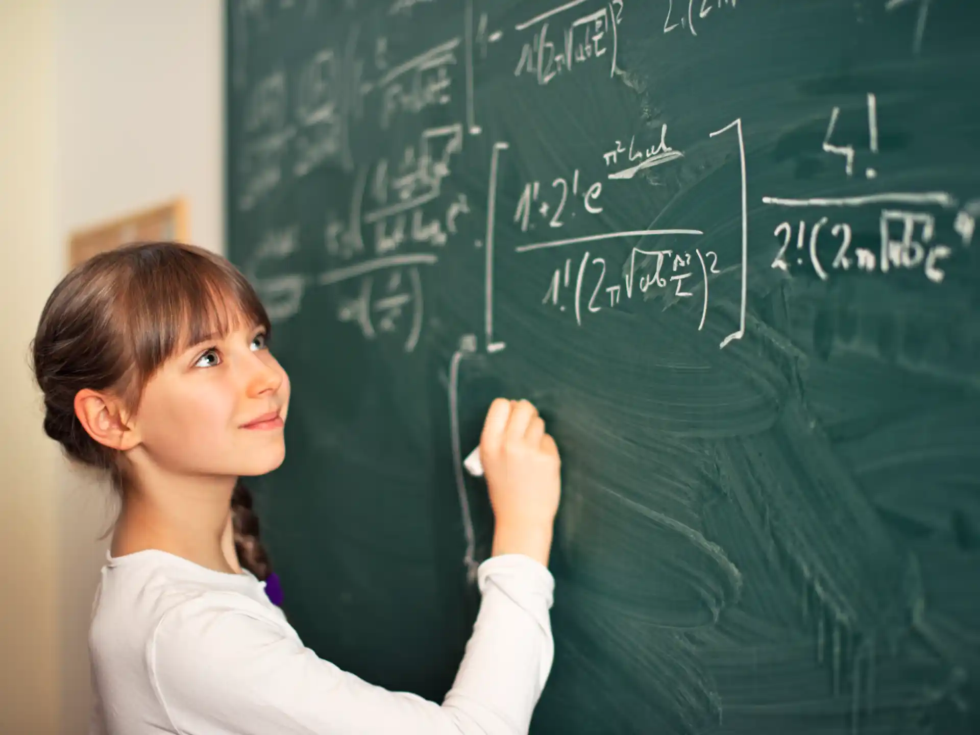 a young girl writing on a chalkboard