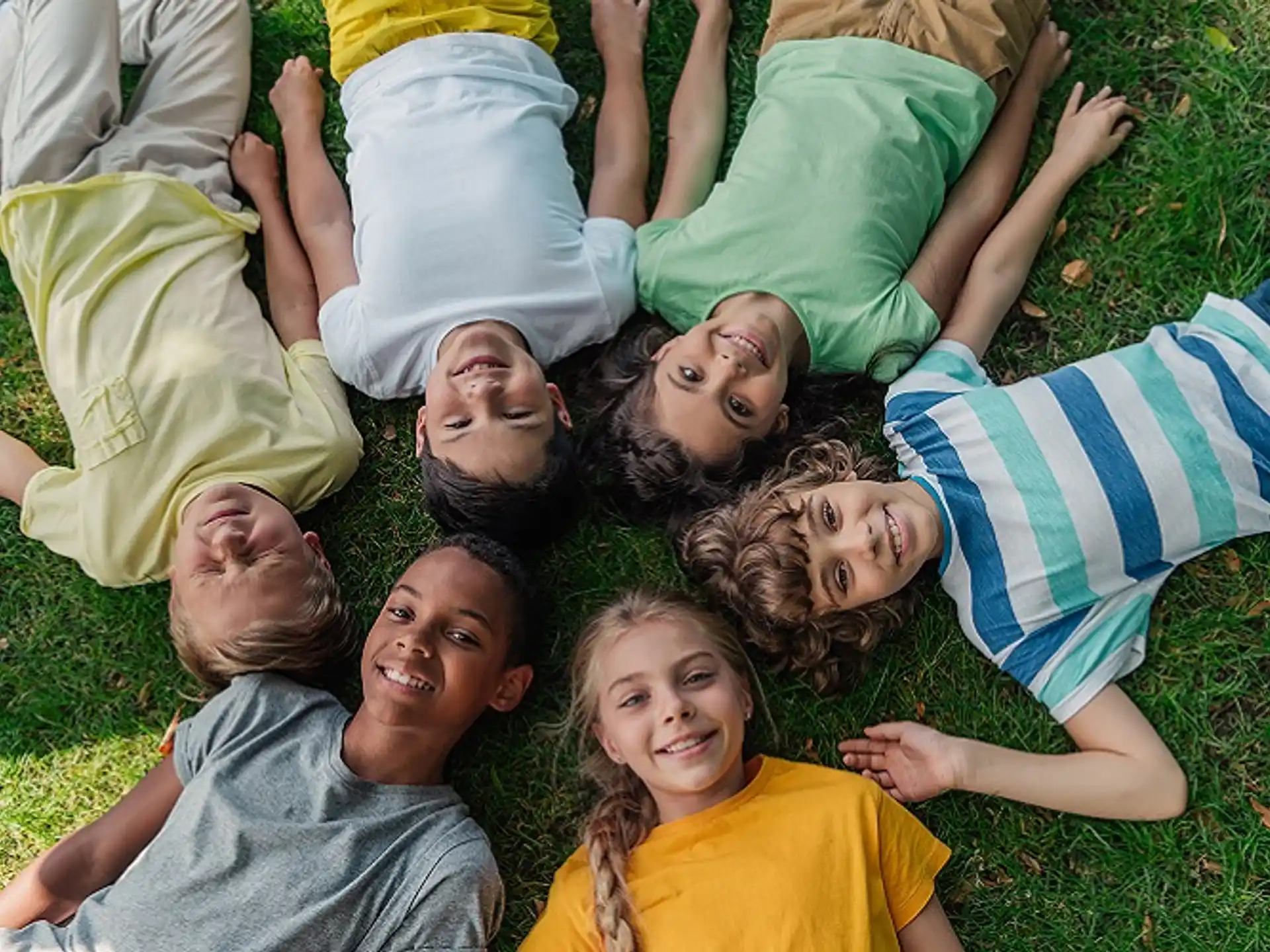 a group of children lying on the grass