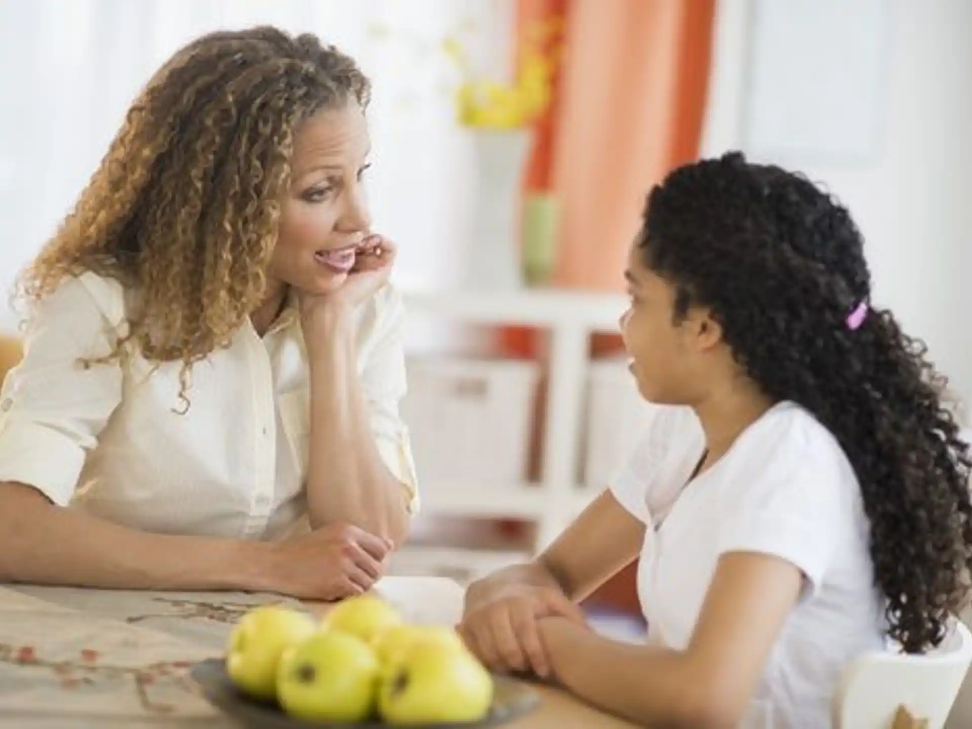 a person and a child looking at a fruit on a table