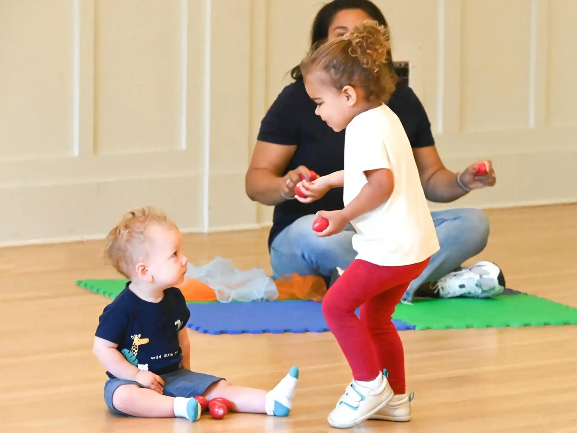 a person and two children playing on the floor