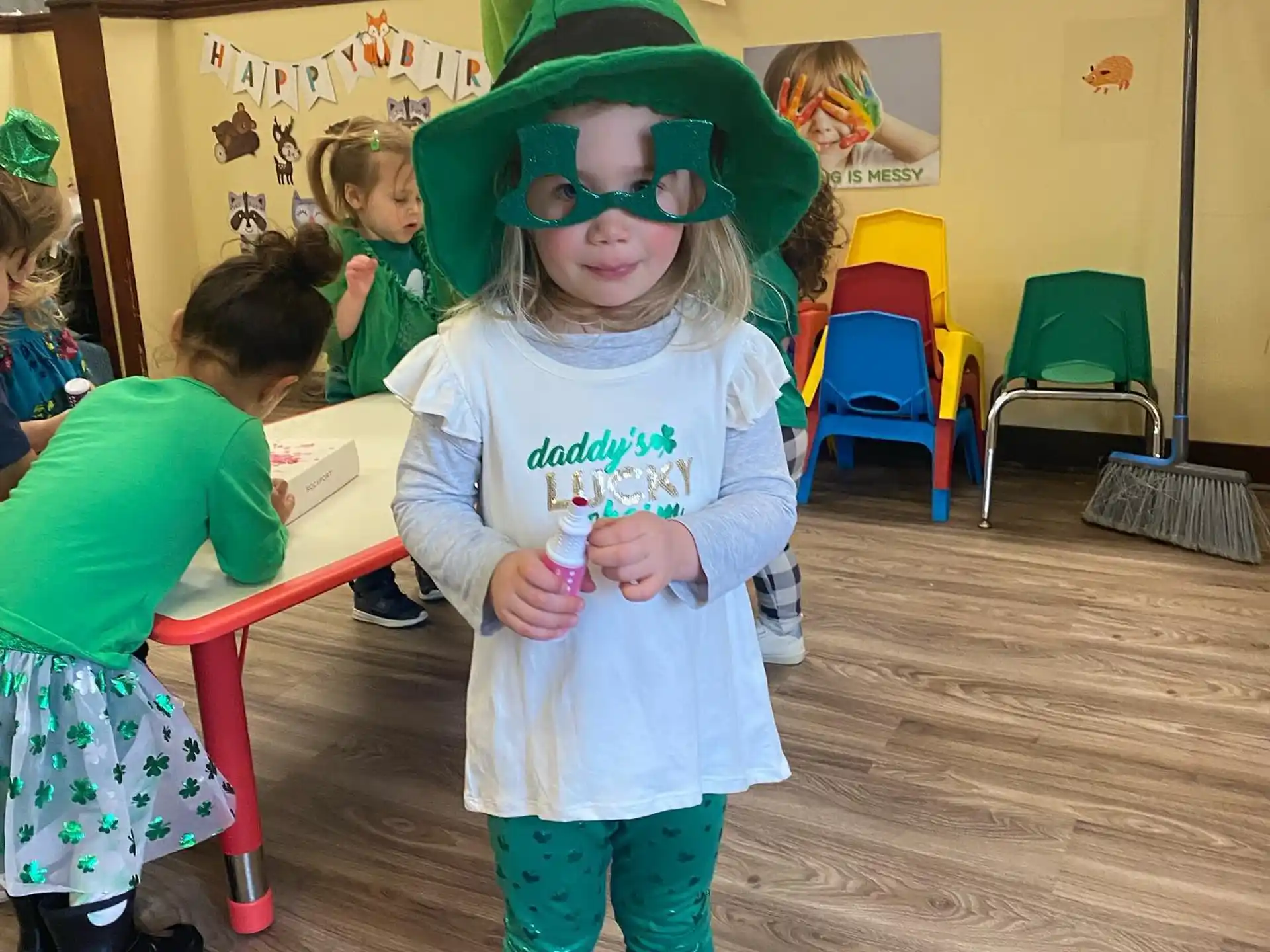 a child wearing a green hat and a green bow tie