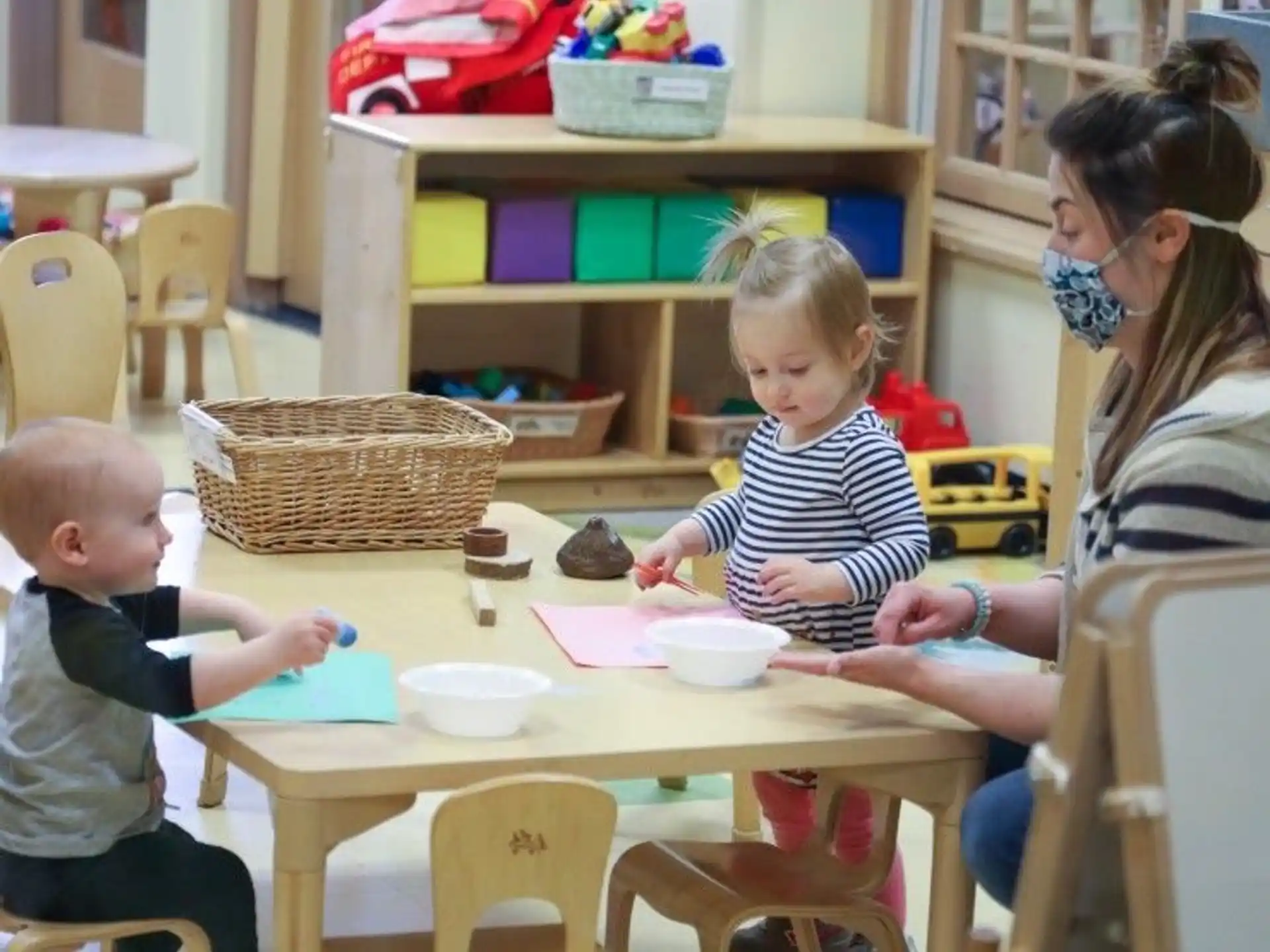 a person and a child sitting at a table with a cupcake