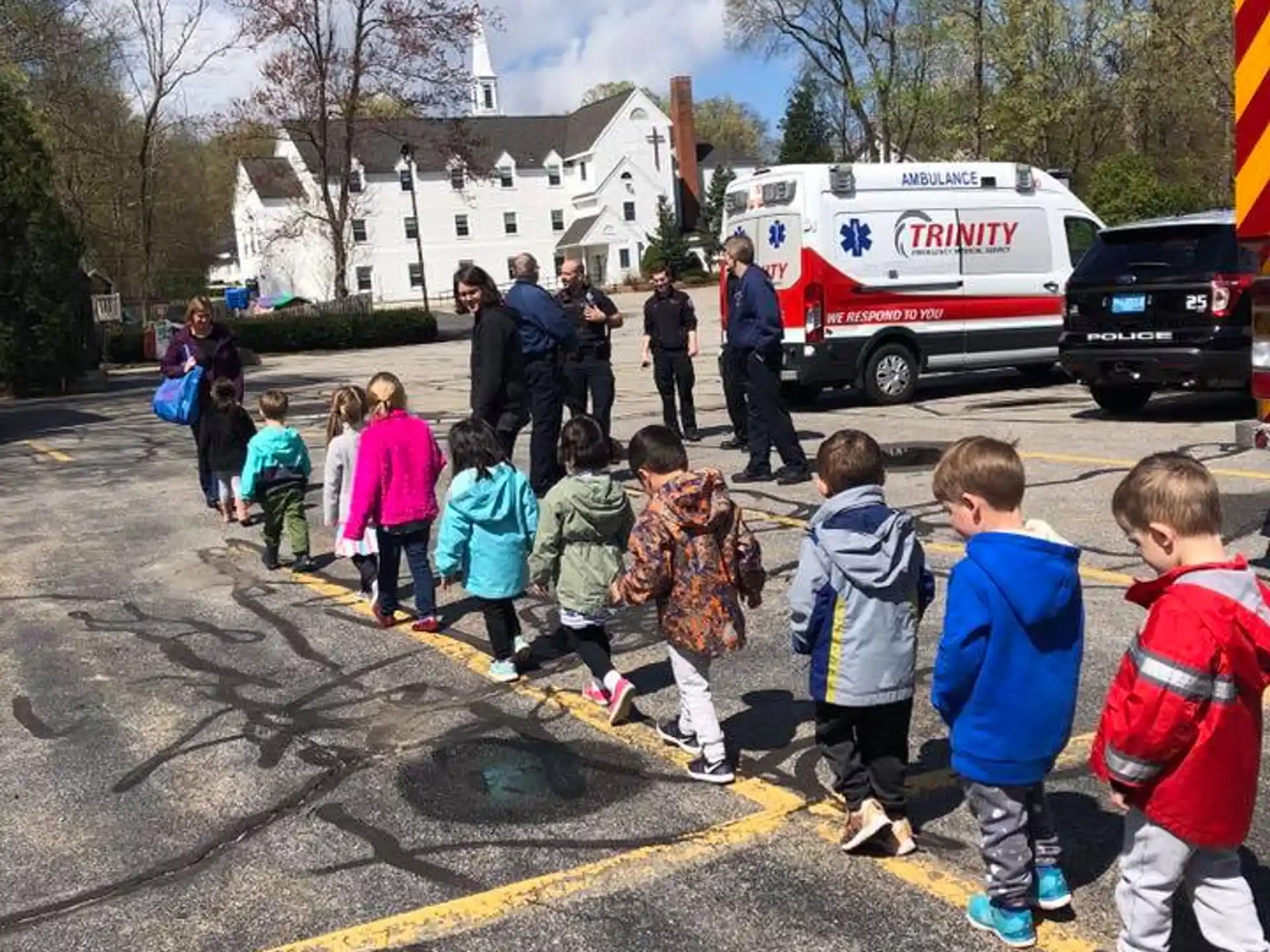 a group of children standing in a parking lot