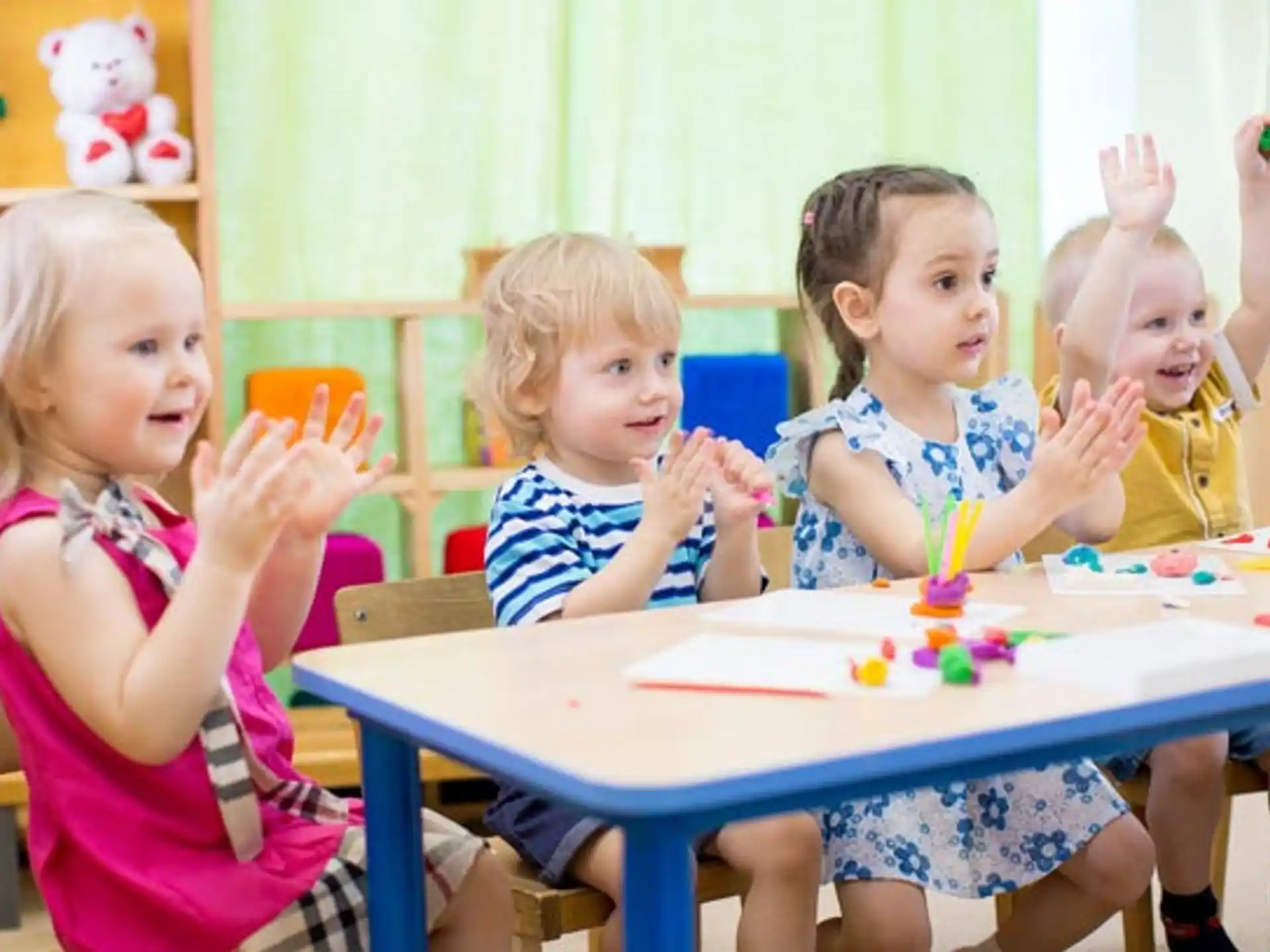 a group of children sitting at a table with a cake