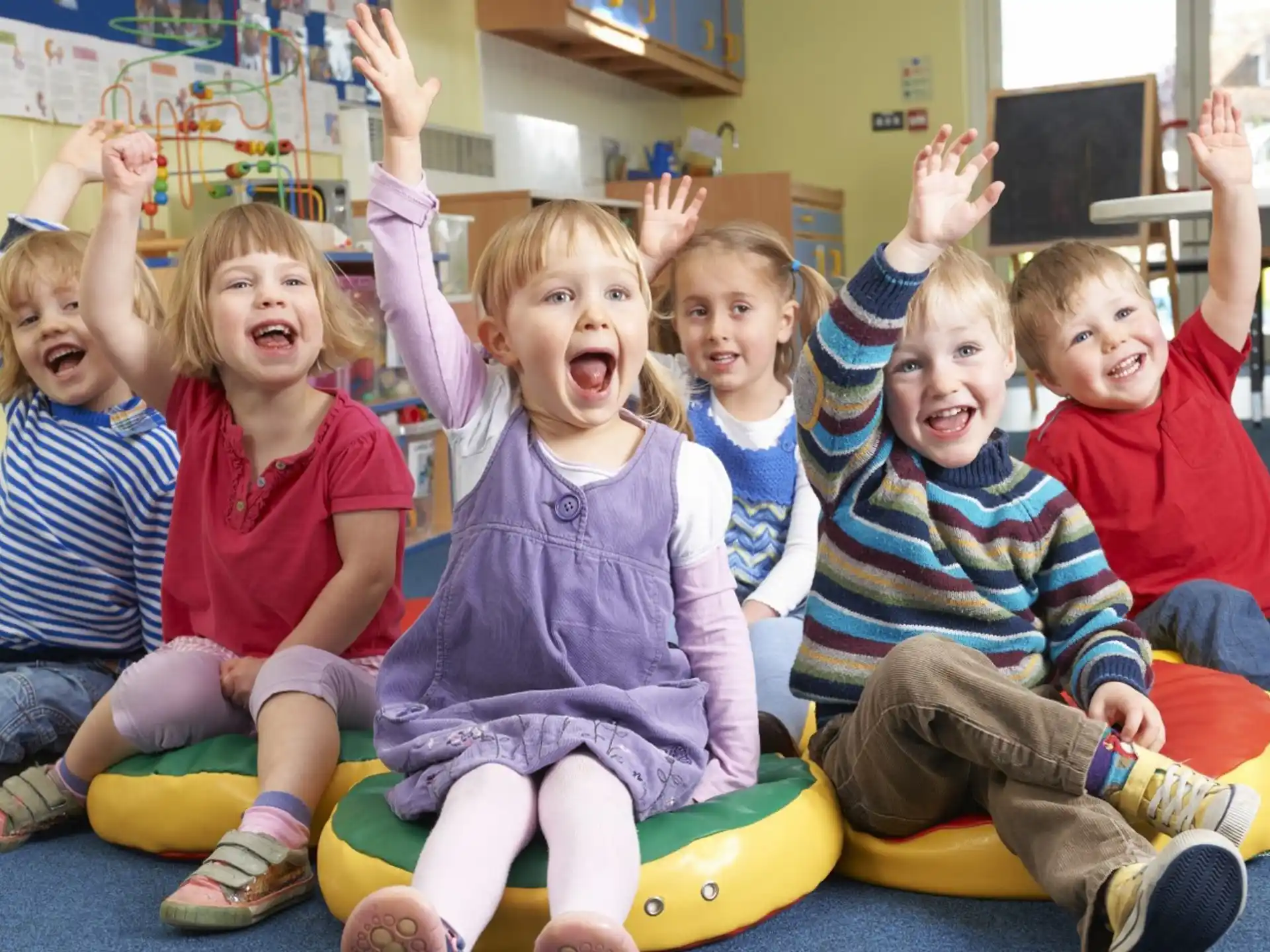 a group of children sitting on a yellow and green toy