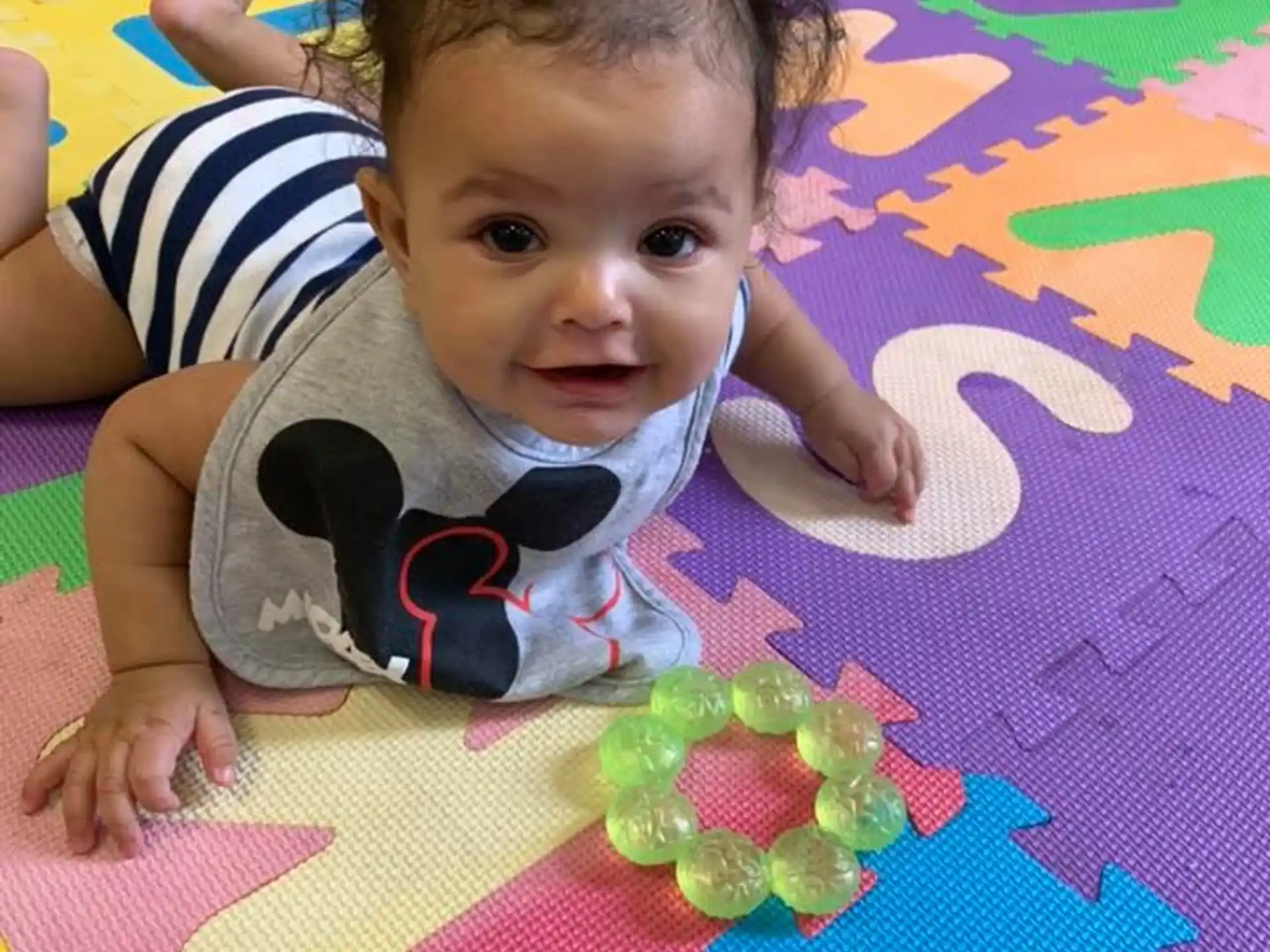 a baby lying on a colorful blanket