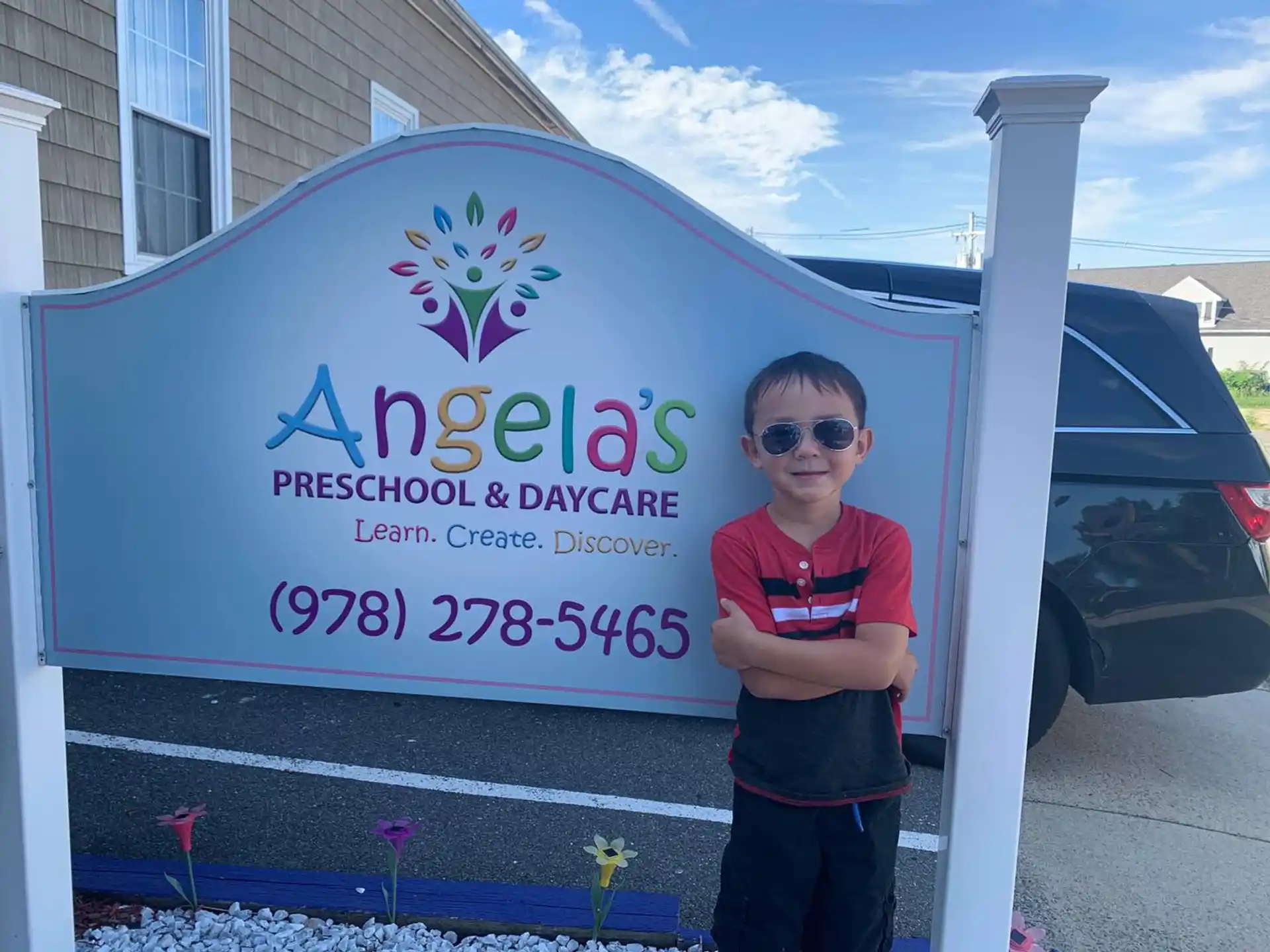 a boy standing in front of a sign