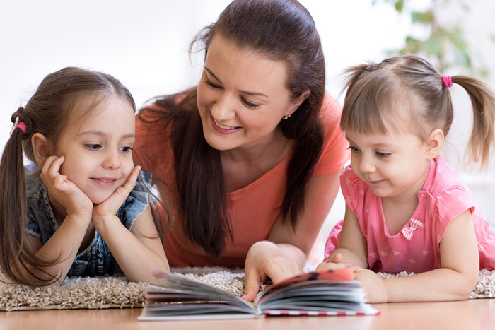a person and two children looking at a tablet