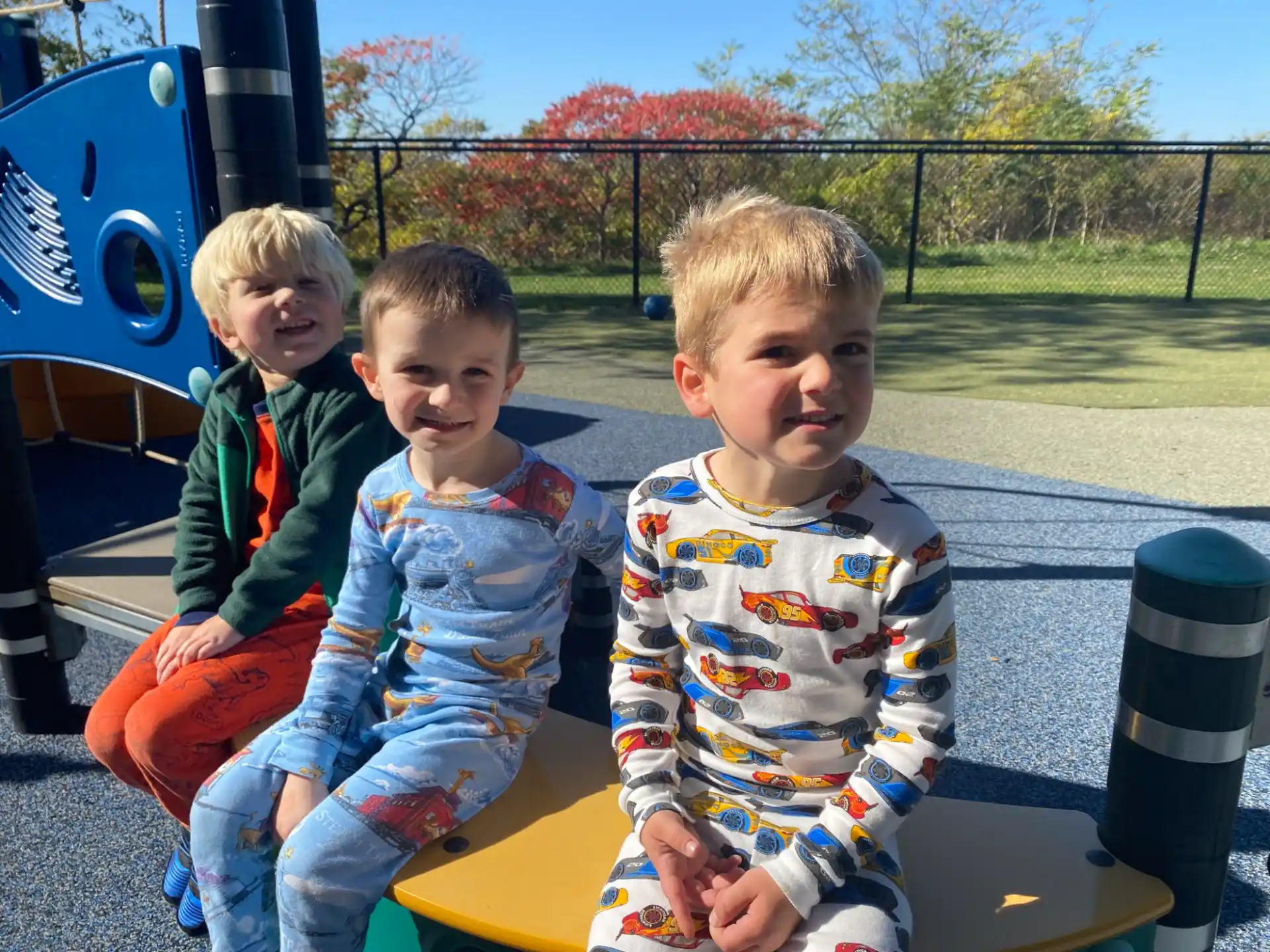 a group of children sitting on a playground toy