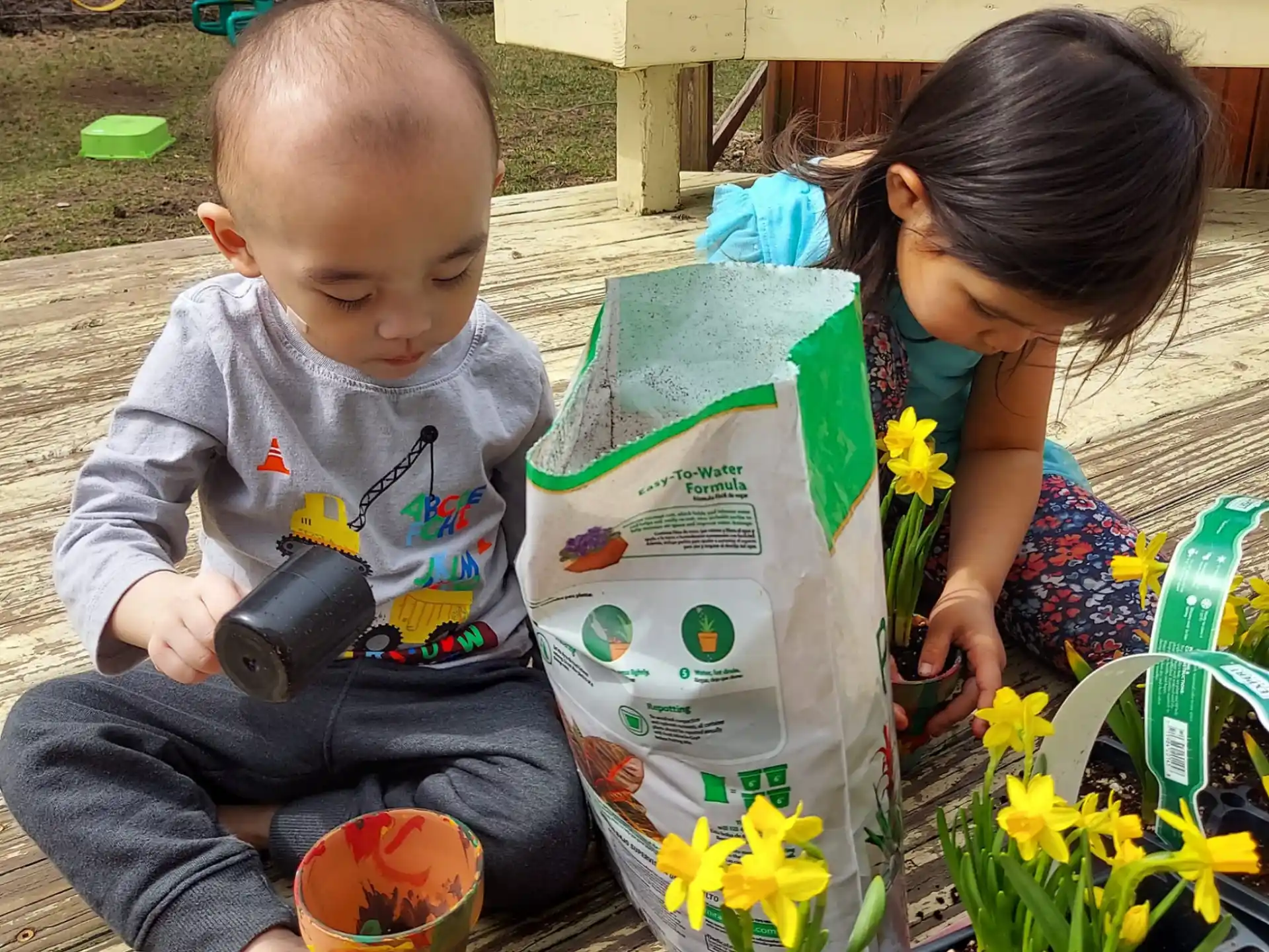 a baby and a person planting flowers