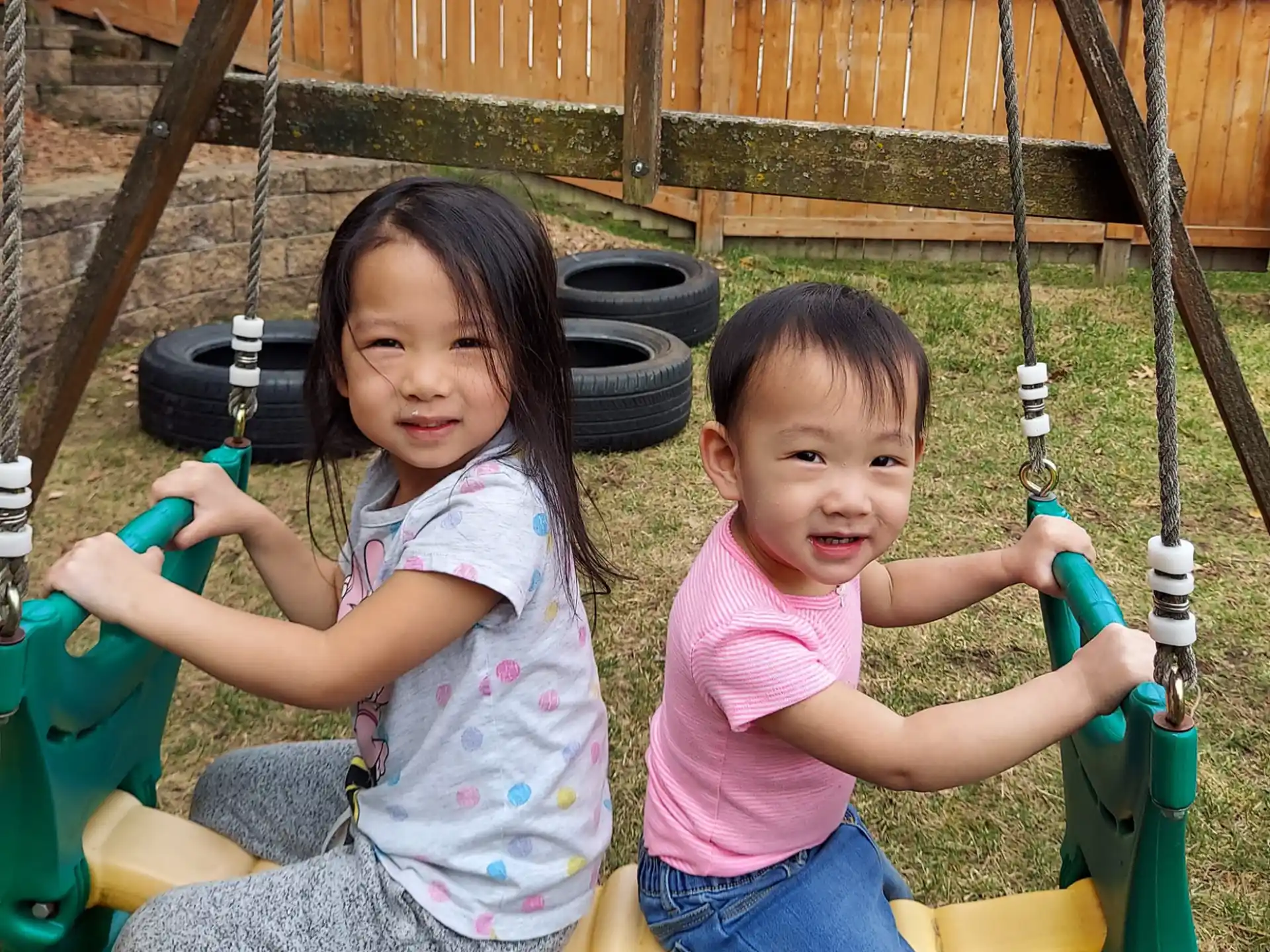 a couple of children on a swing set