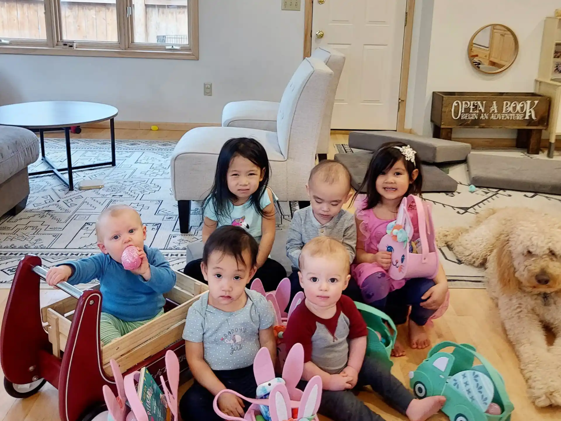 a group of children sitting on the floor with toys and a dog