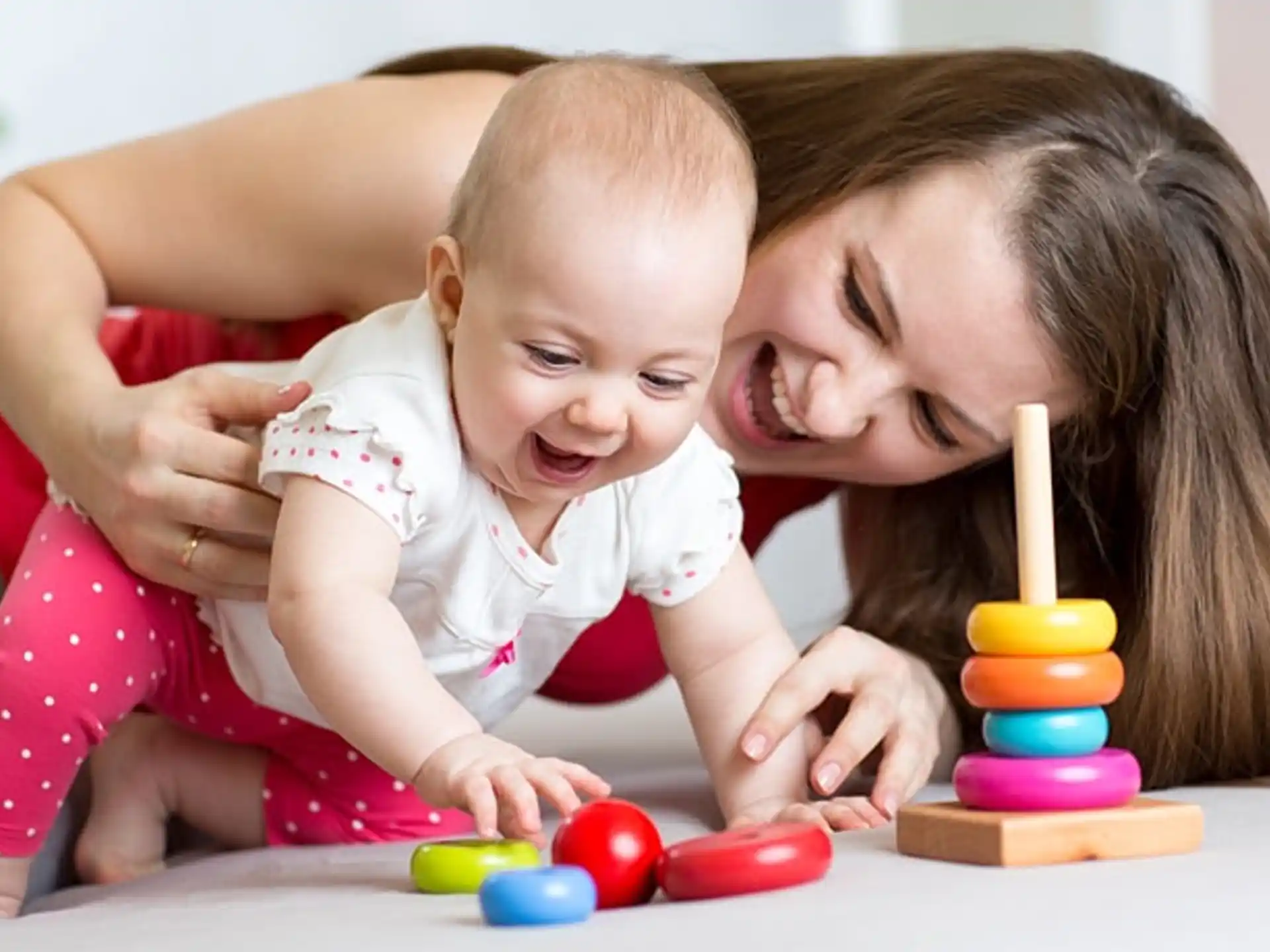 a person and a baby playing with toys