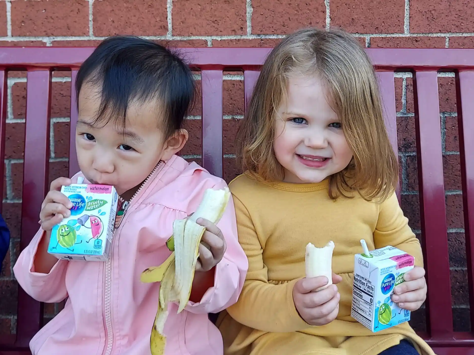 two children sitting on a bench