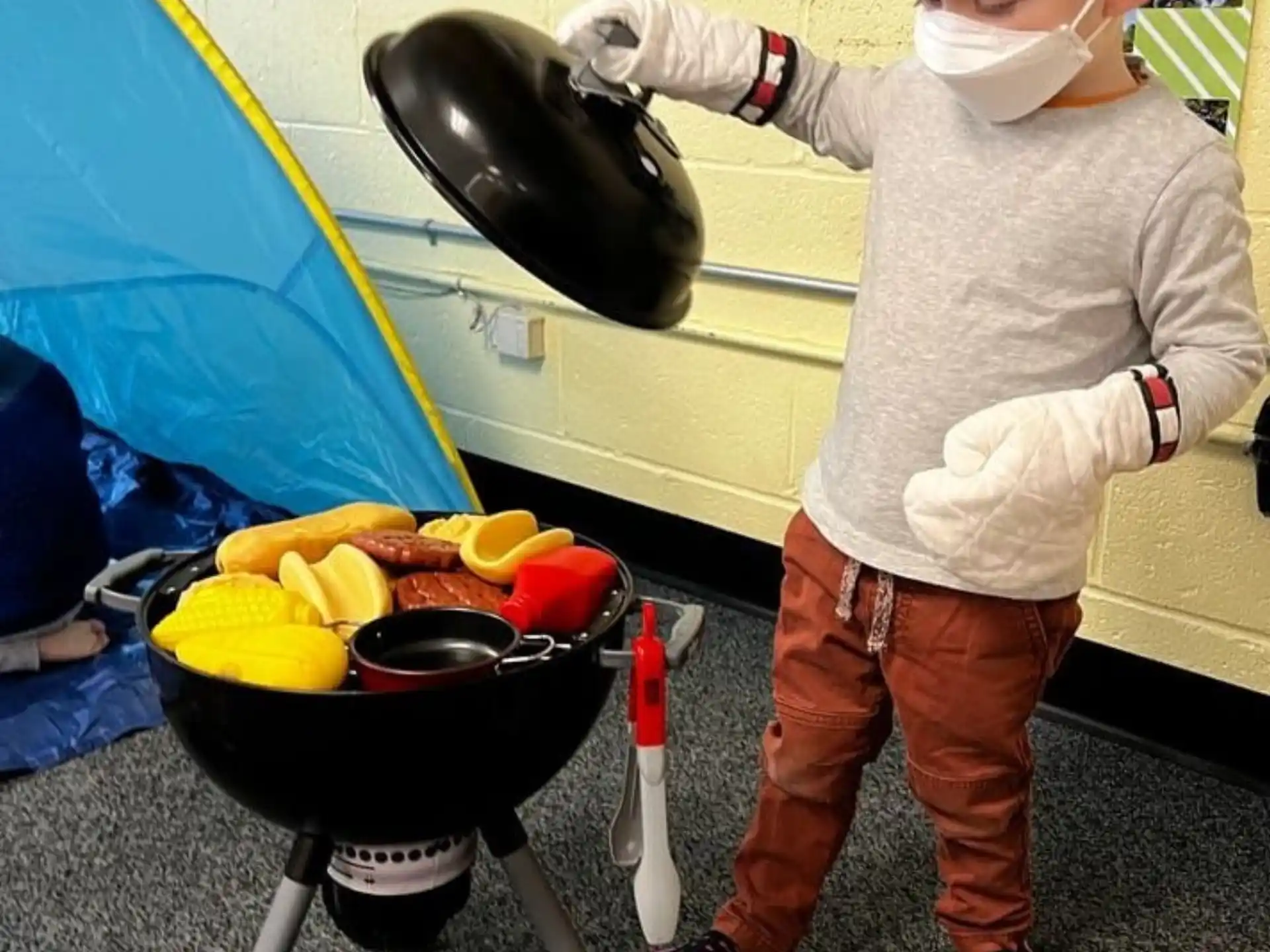a child cooking food on a grill