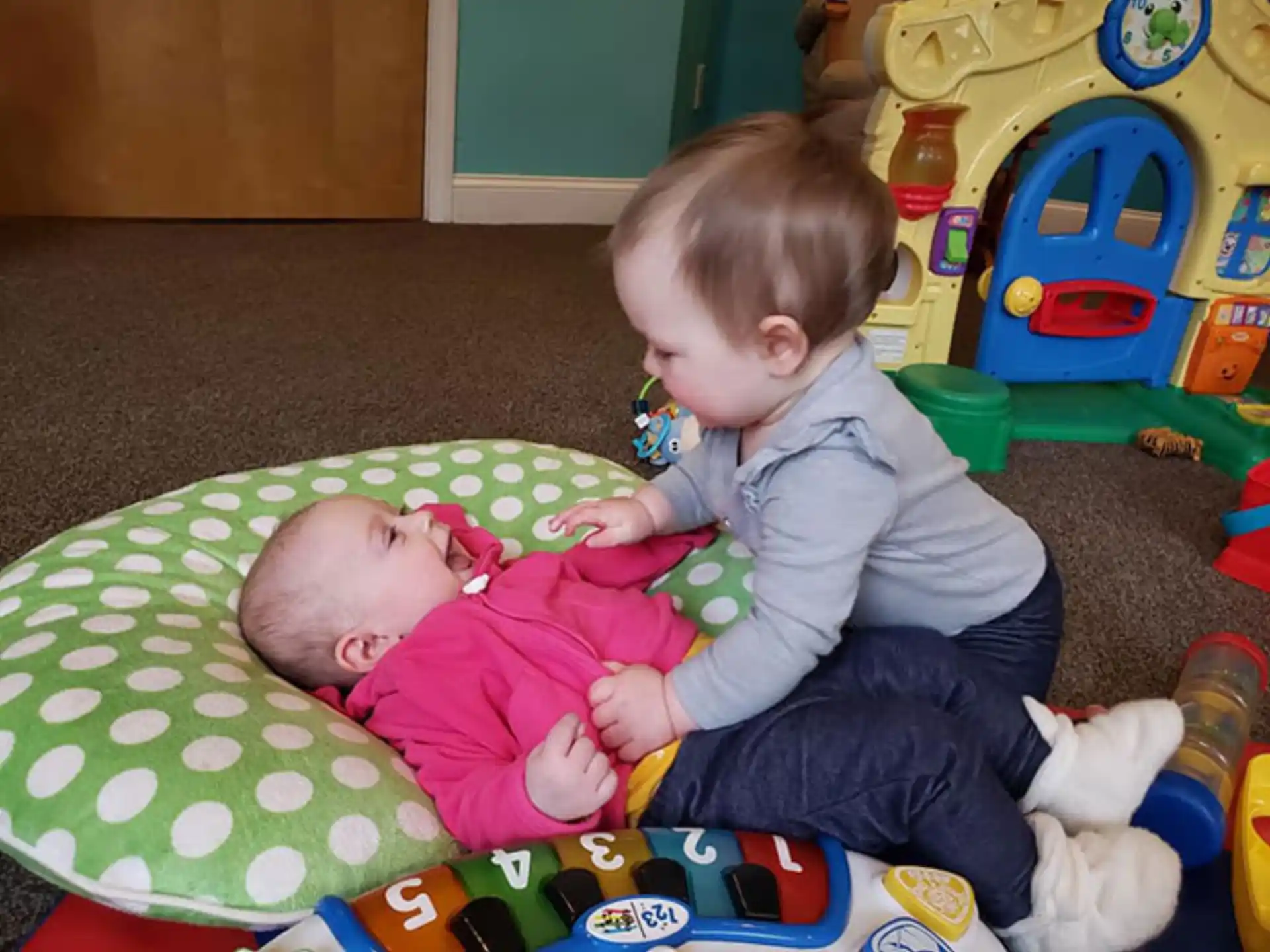a baby and a baby lying on a carpet