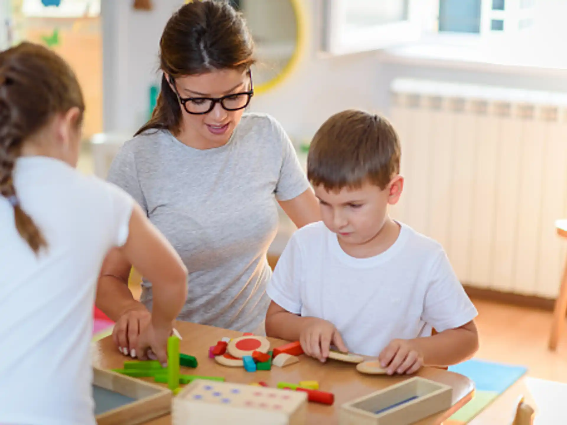 a woman and two children playing with toys