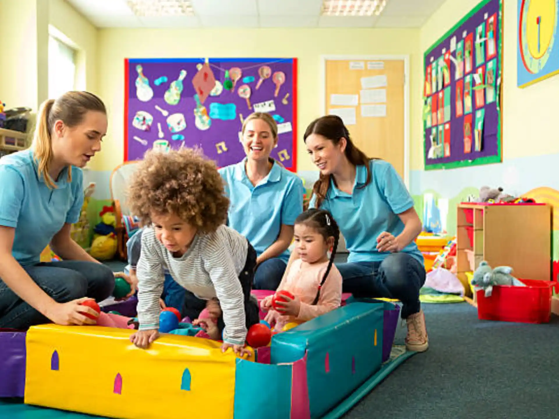 a group of people sitting on a colorful box in a classroom