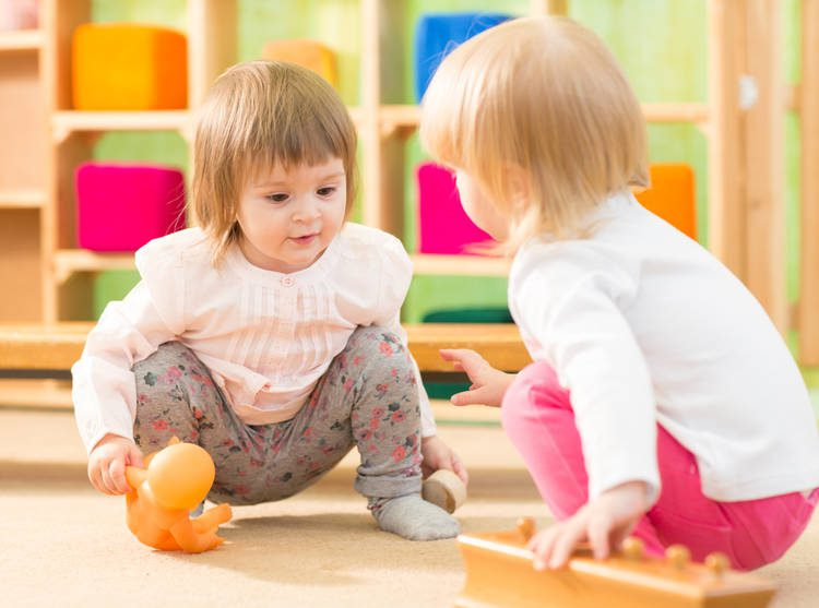 a couple of children playing with a pumpkin